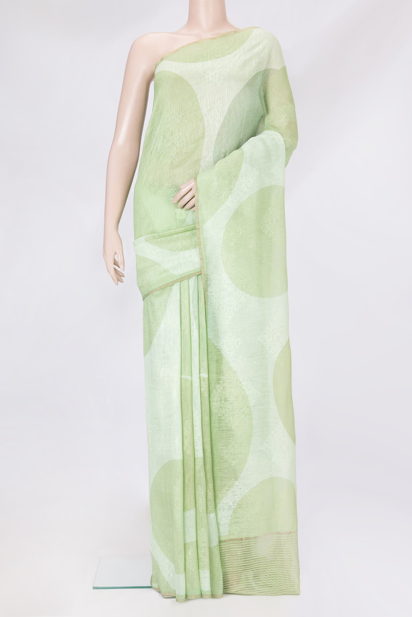 Pista Green Linen Saree with Embroidery on the body and Zari Border.  displayed on a mannequin