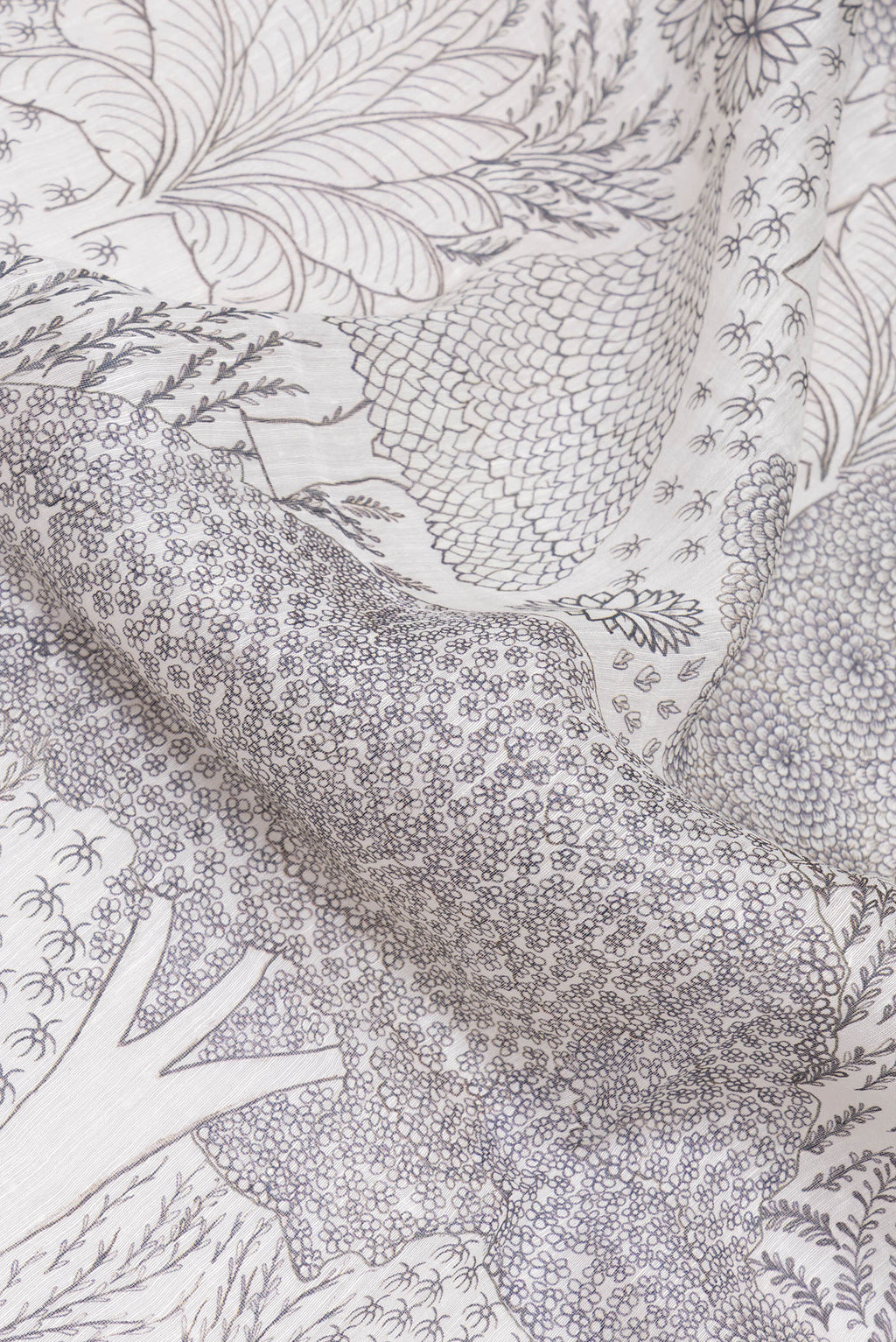 Close up of Off White Linen Saree with Printed design on the body and Embroidery Border.  displaying folds