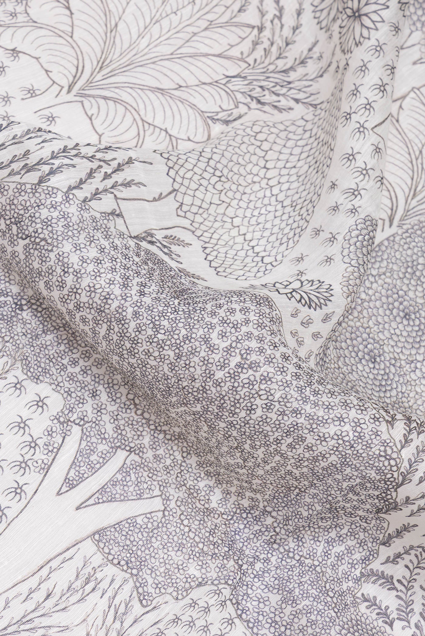 Close up of Off White Linen Saree with Printed design on the body and Embroidery Border.  displaying folds