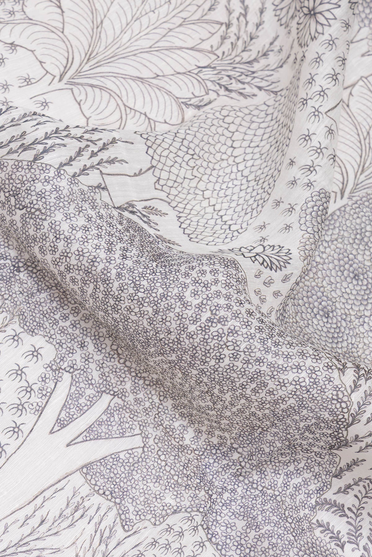 Close up of Off White Linen Saree with Printed design on the body and Embroidery Border.  displaying folds