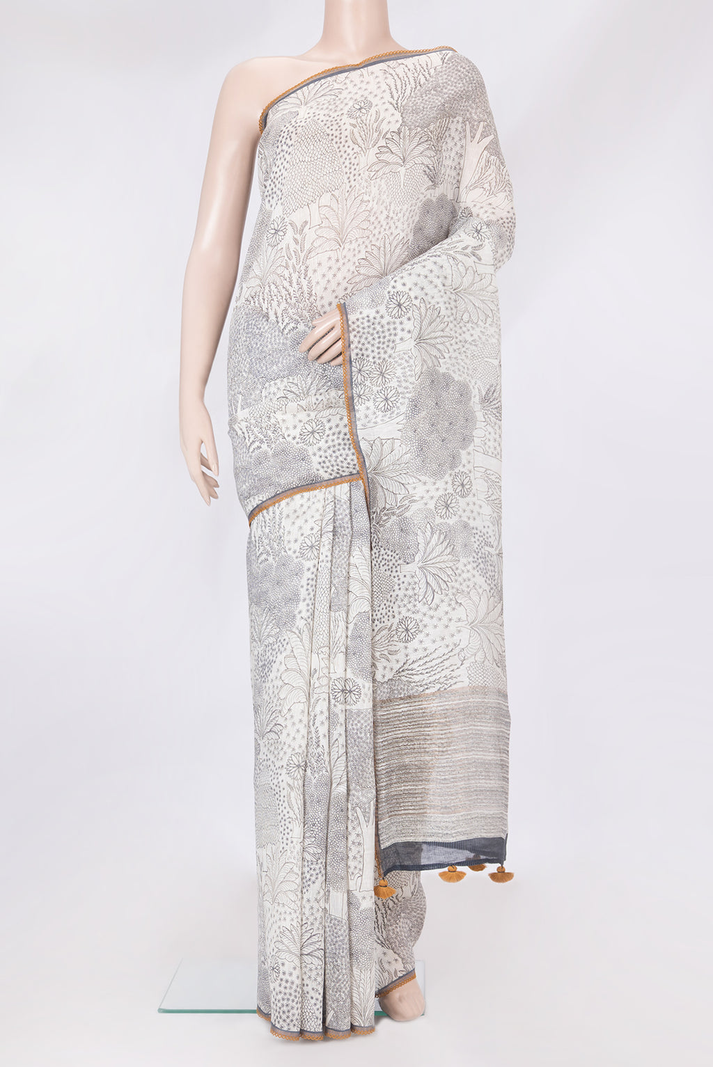 Off White Linen Saree with Printed design on the body and Embroidery Border.  displayed on a mannequin