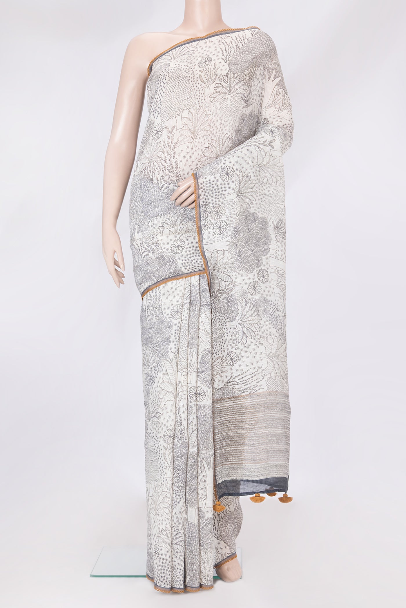 Off White Linen Saree with Printed design on the body and Embroidery Border.  displayed on a mannequin