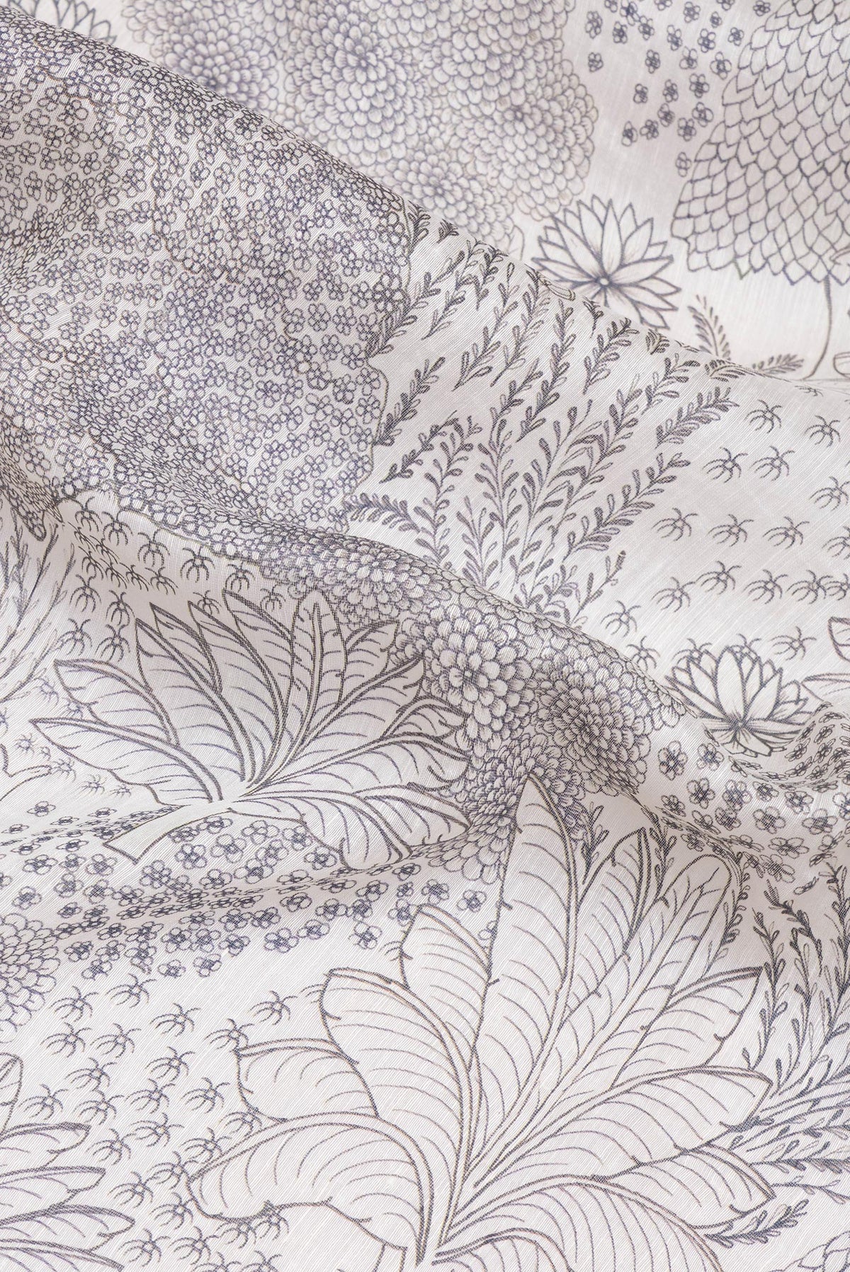 Close up of Off White Linen Saree with Printed design on the body and Embroidery Border.  displaying folds