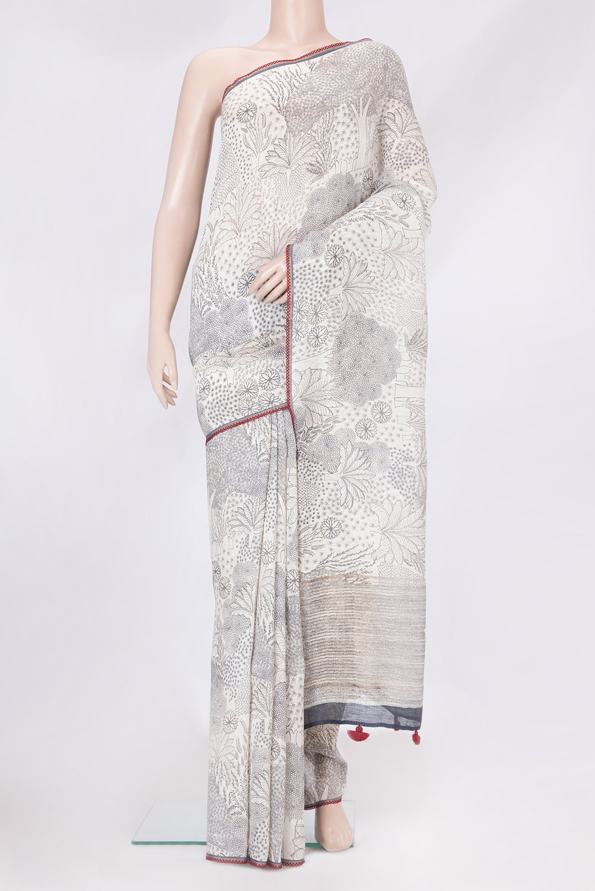 Off White Linen Saree with Printed design on the body and Embroidery Border.  displayed on a mannequin
