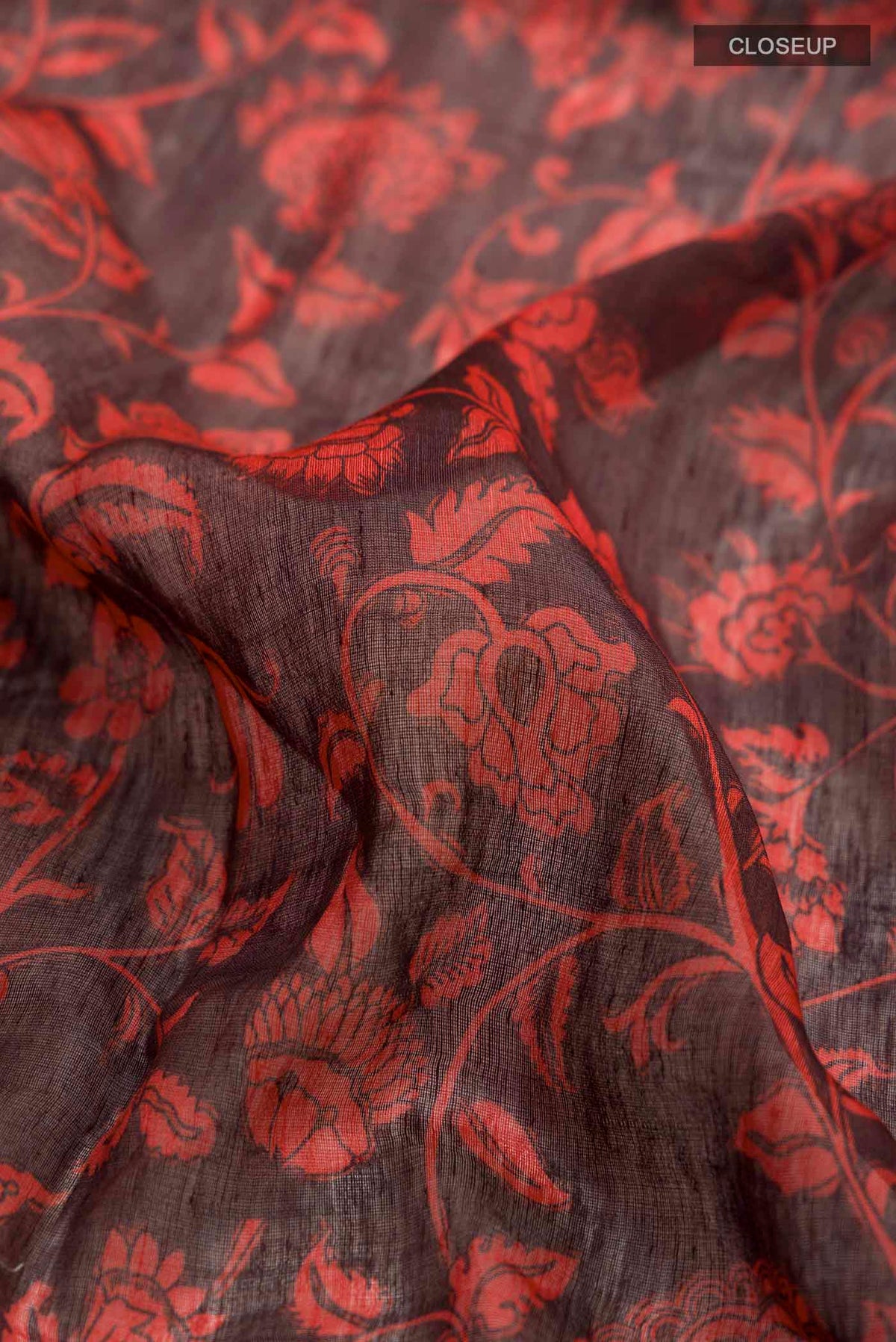 Close up of Red Linen Cotton Saree with Printed design on the body and Zari Border displaying folds