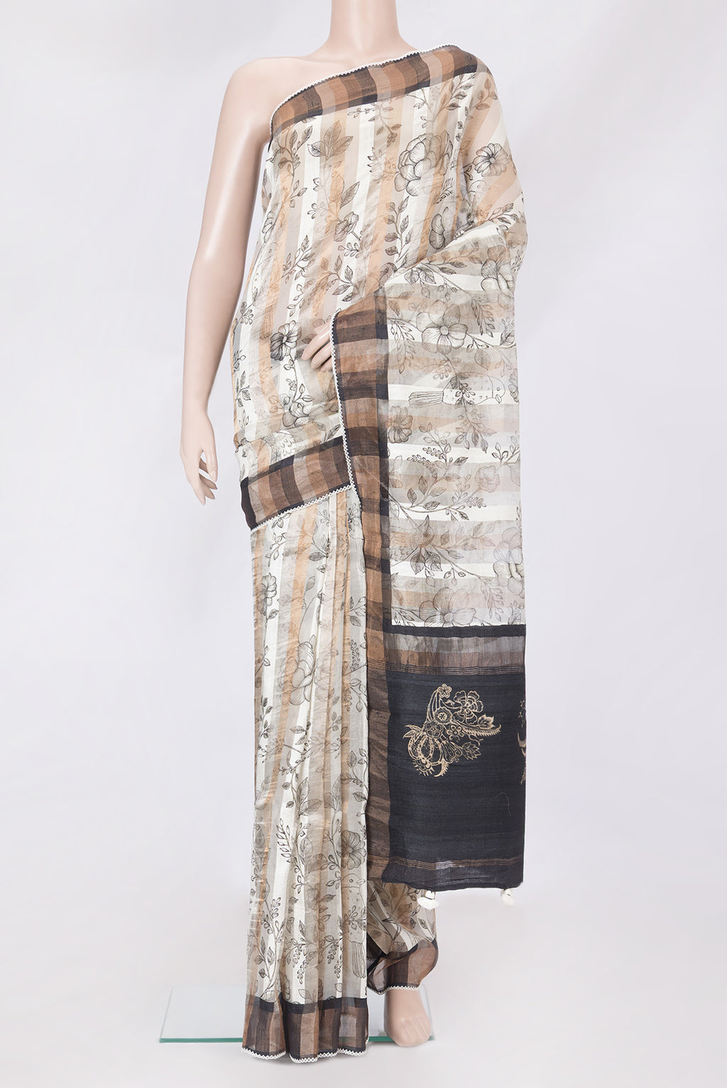 Off White Tussar Silk Saree with Floral Print on the body and Zari Border.  displayed on a mannequin