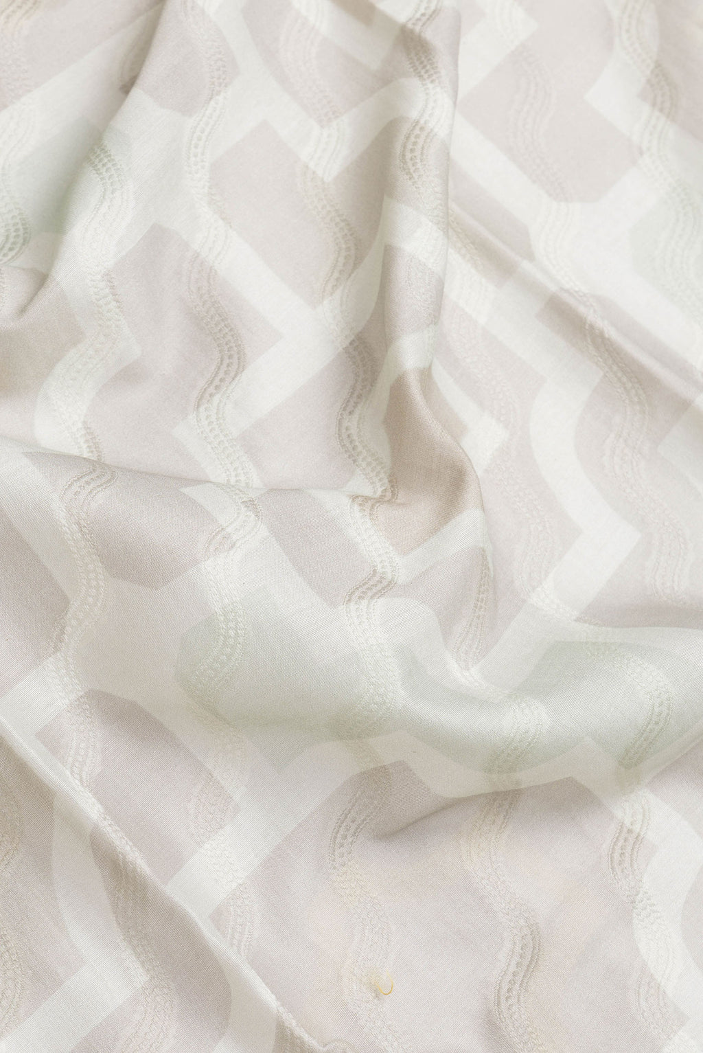 Close up of Grey Dual Tone Chanderi Silk Saree with Thread Butta on the body and Zari And Thread Border.  displaying folds