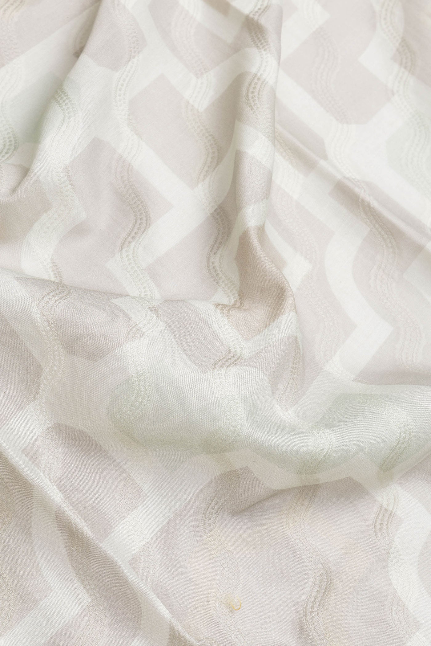 Close up of Grey Dual Tone Chanderi Silk Saree with Thread Butta on the body and Zari And Thread Border.  displaying folds