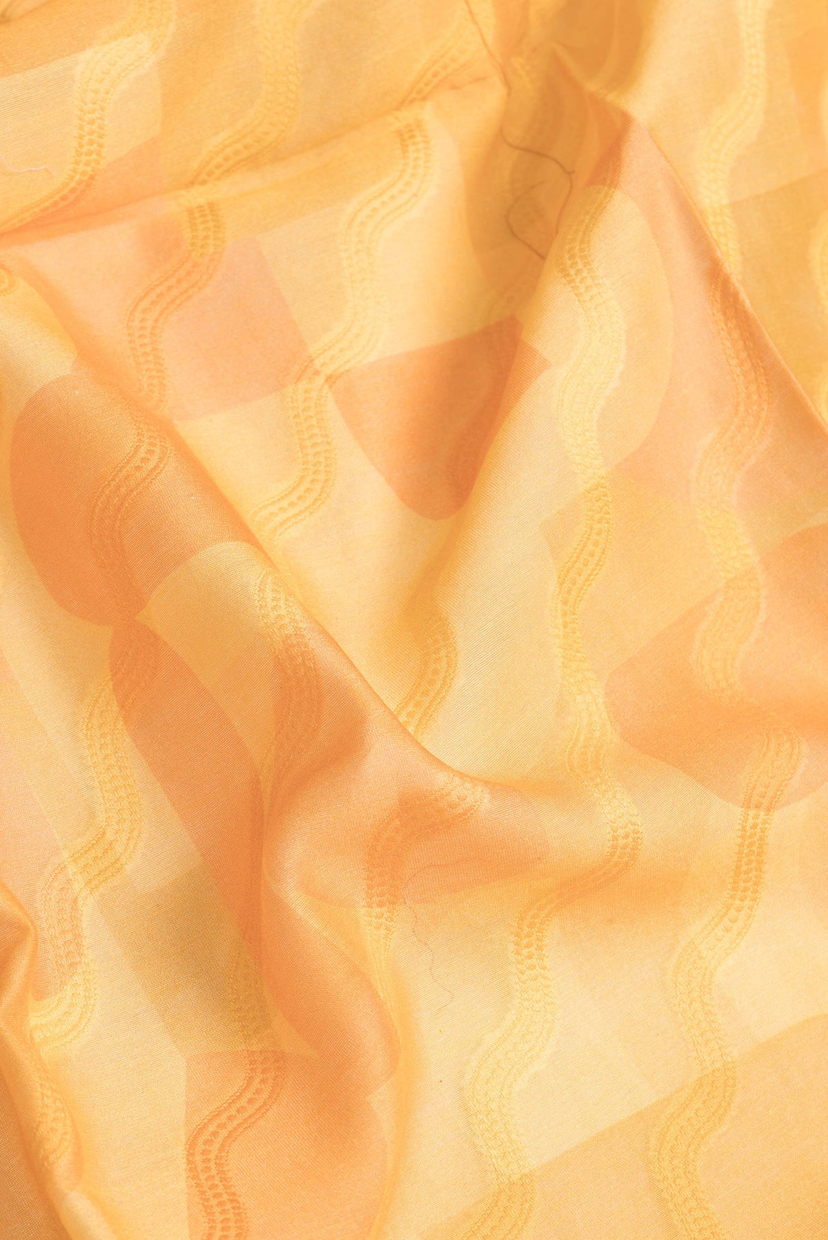 Close up of Orange Dual Tone Chanderi Silk Saree with Thread Butta on the body and Zari And Thread Border.  displaying folds