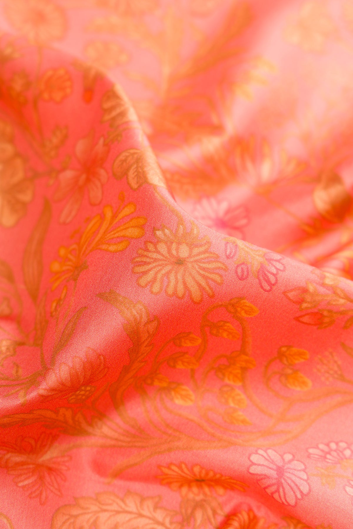 Close up of Peach Printed Silk Saree with Printed design on the body and Zari Border.  displaying folds