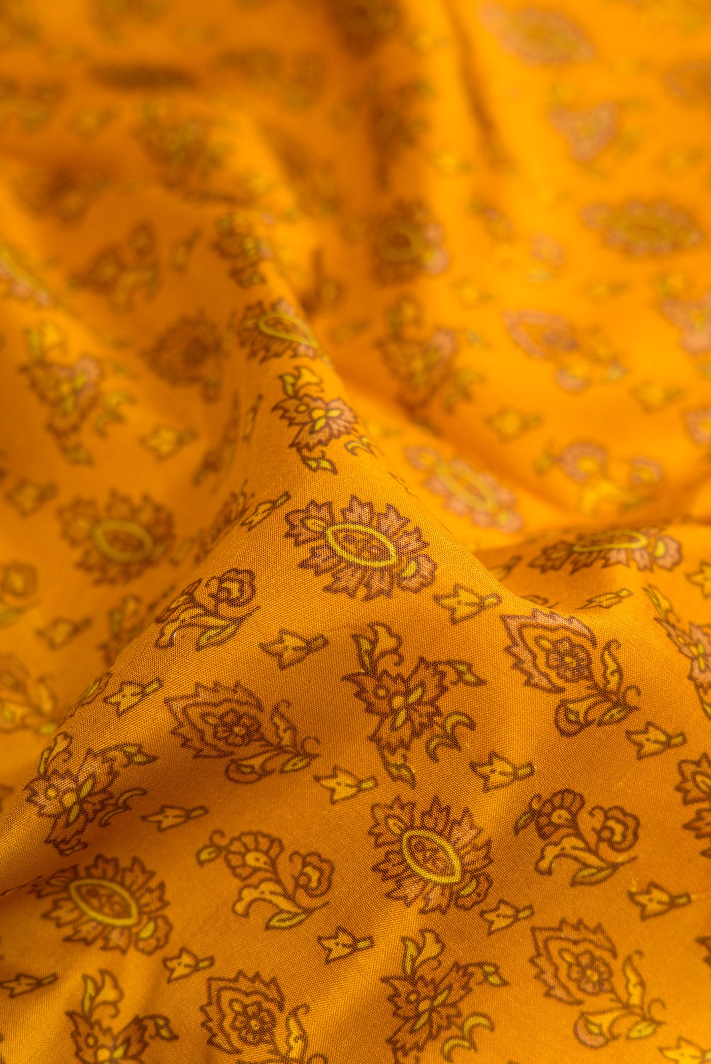 Close up of Mustard Dual Tone Printed Silk Saree with Printed design on the body and Printed Border.  displaying folds