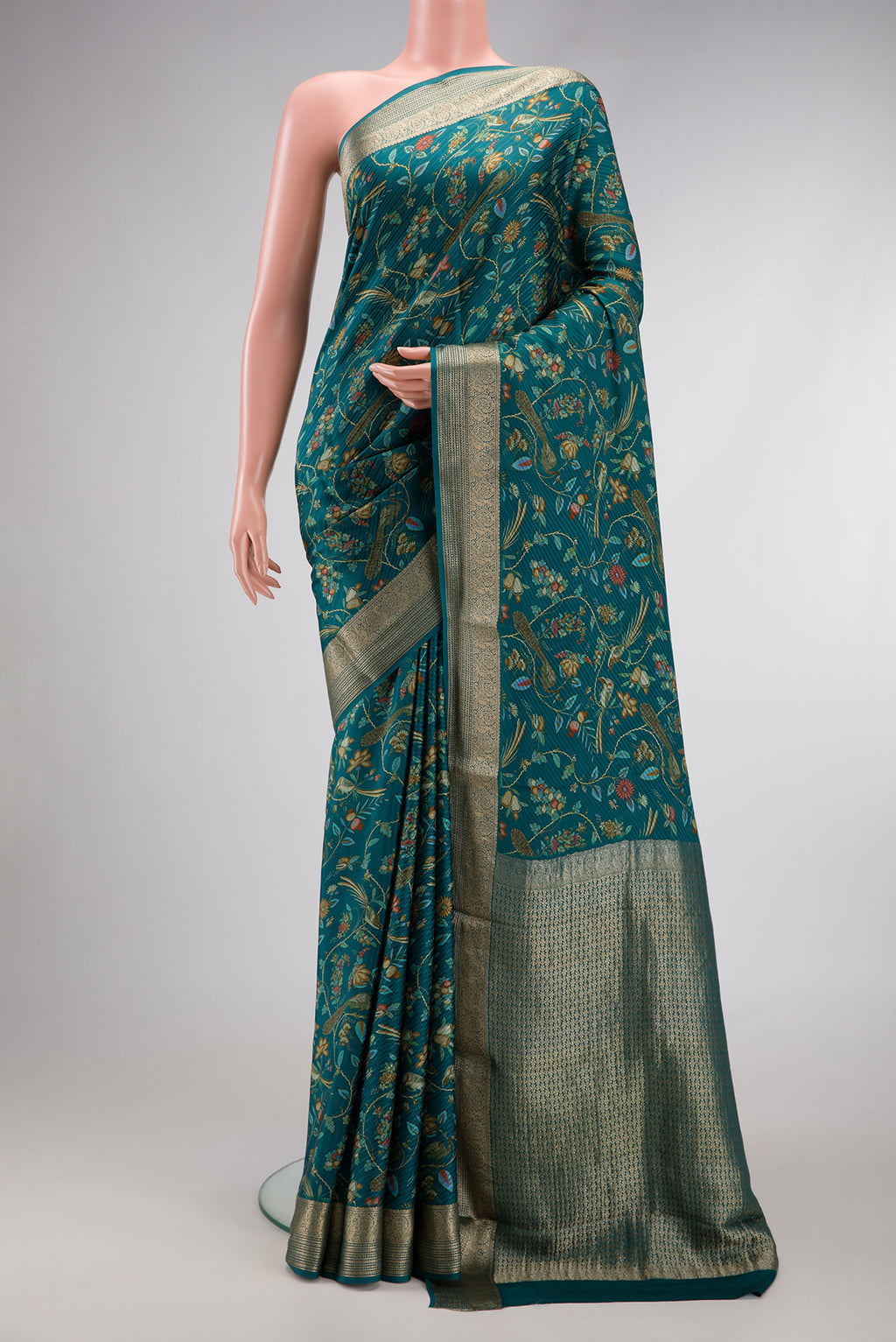 Peacock Blue Dual Tone Mysore Crepe Saree with Printed design on the body and Zari Border.  displayed on a mannequin