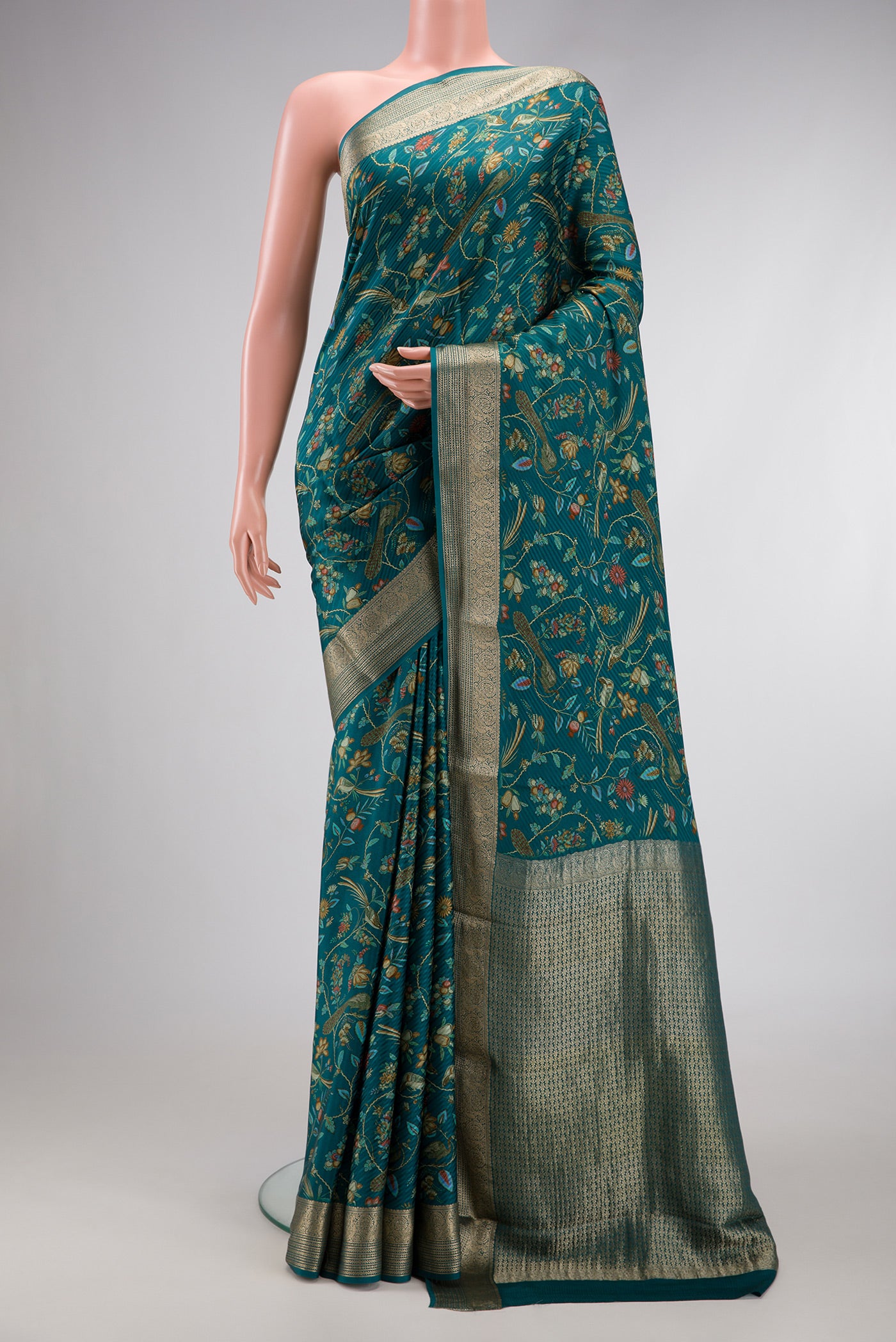 Peacock Blue Dual Tone Mysore Crepe Saree with Printed design on the body and Zari Border.  displayed on a mannequin