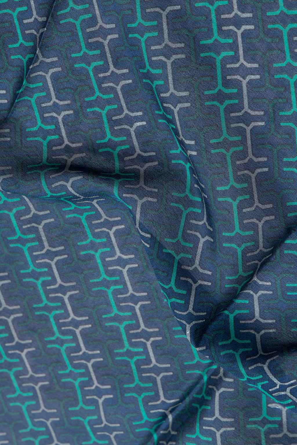 Close up of Peacock Blue Dual Tone Crepe Saree with Printed design on the body and Zari Border.  displaying folds