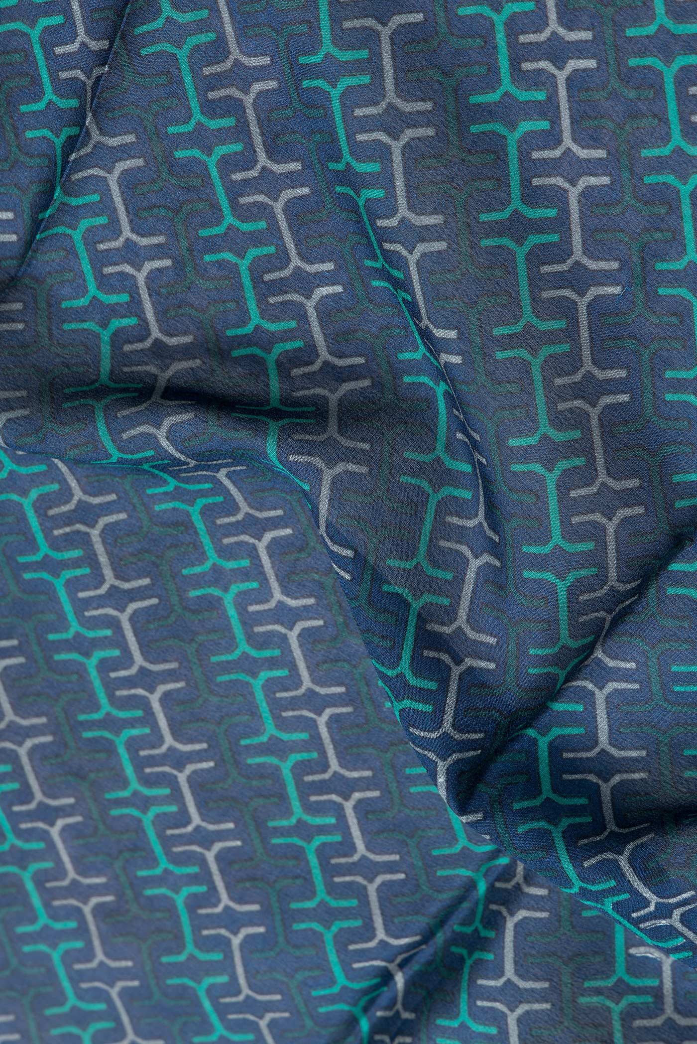Close up of Peacock Blue Dual Tone Crepe Saree with Printed design on the body and Zari Border.  displaying folds