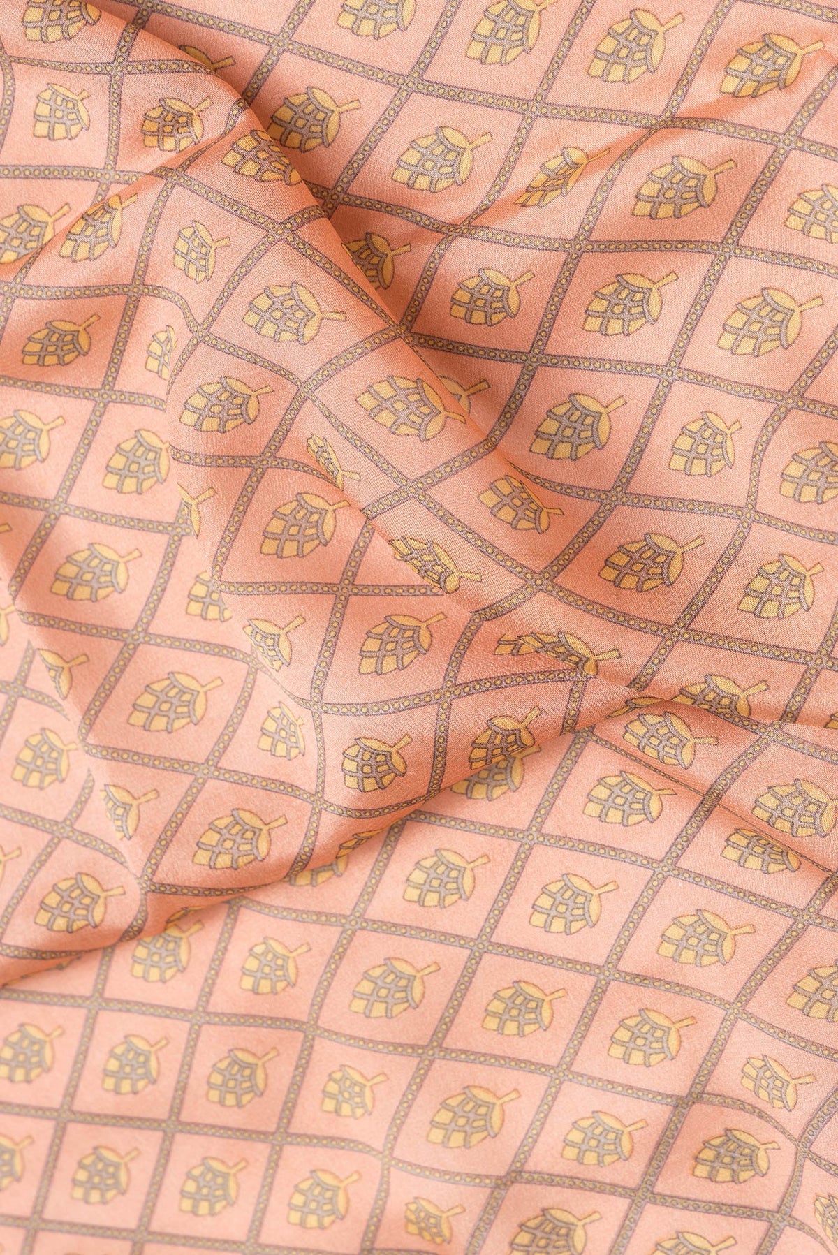 Close up of Peach Dual Tone Crepe Saree with Printed design on the body and Zari Border.  displaying folds