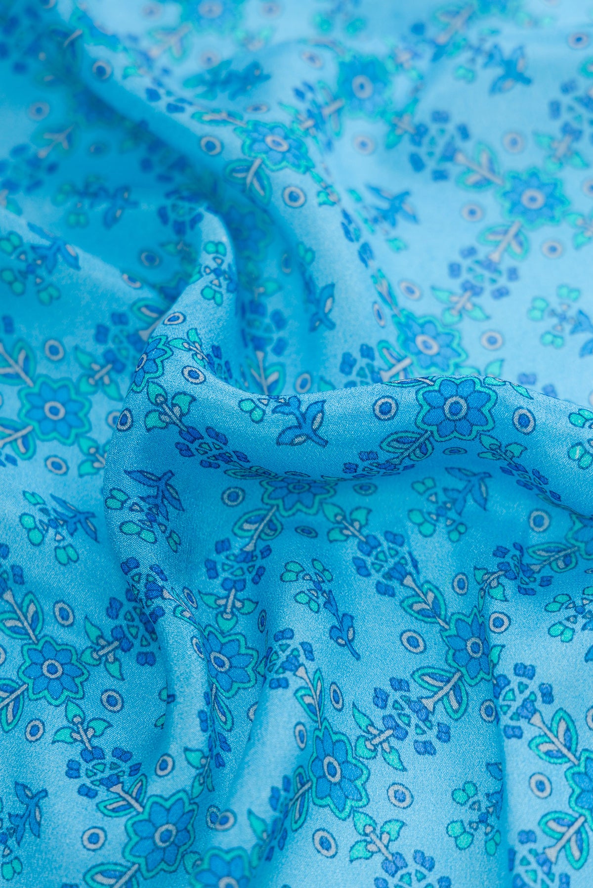 Close up of Sky Blue Dual Tone Mysore Crepe Saree with Printed design on the body and Zari Border.  displaying folds