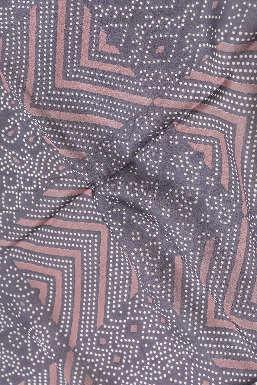Close up of Brown Dual Tone Crepe Saree with Printed design on the body and Zari Border.  displaying folds