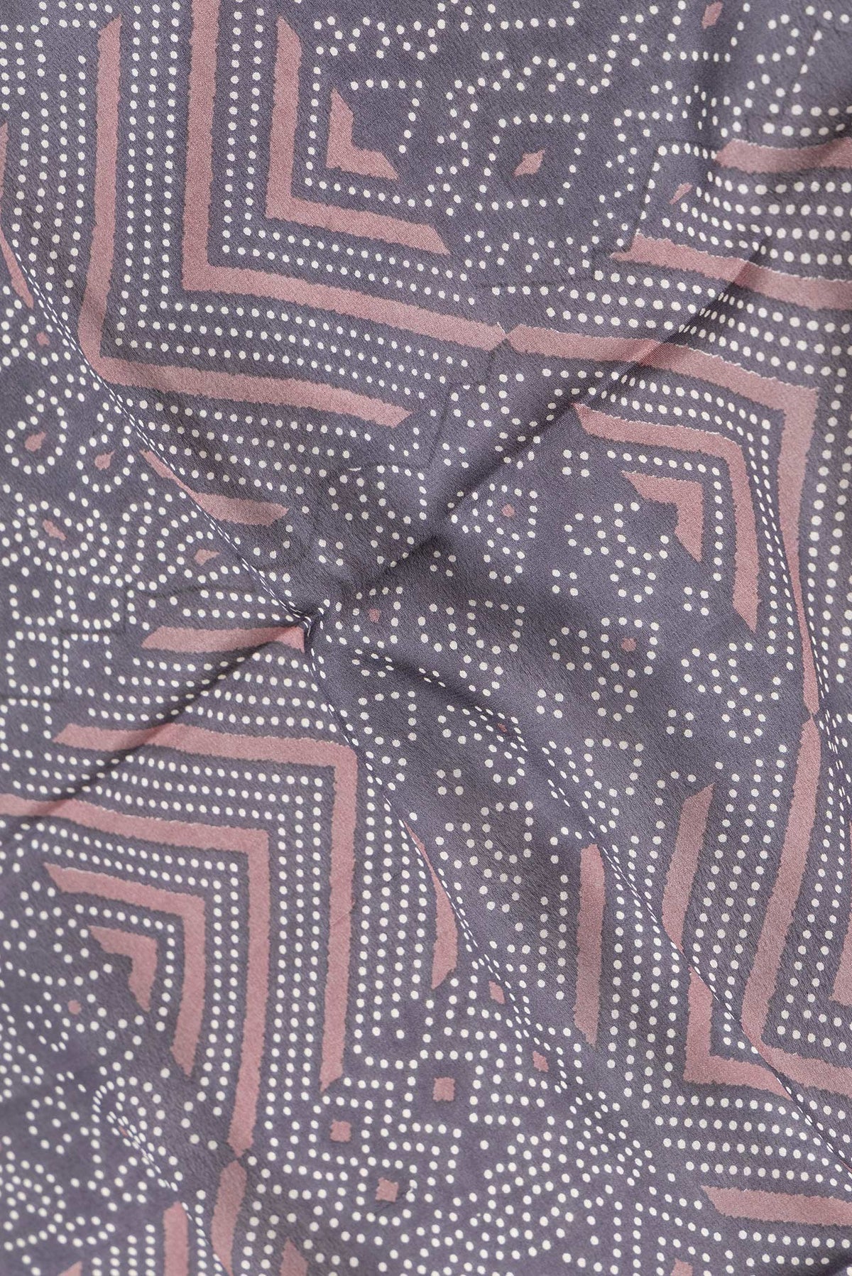 Close up of Brown Dual Tone Crepe Saree with Printed design on the body and Zari Border.  displaying folds
