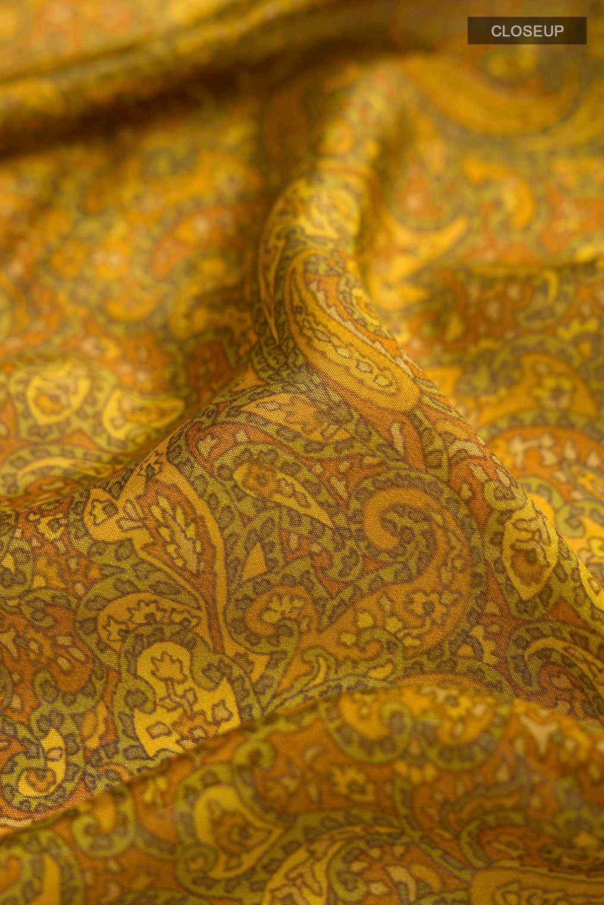 Close up of Mustard Mysore Crepe Saree with Printed design on the body and Zari Border displaying folds