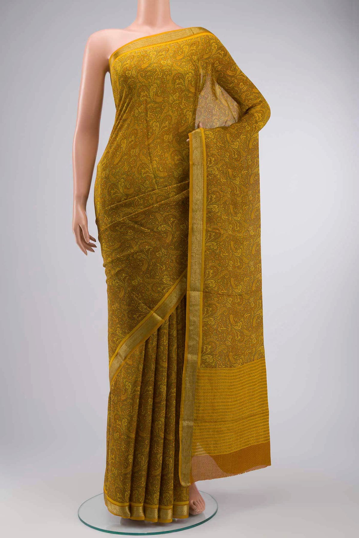 Mustard Mysore Crepe Saree with Printed design on the body and Zari Border displayed on a mannequin