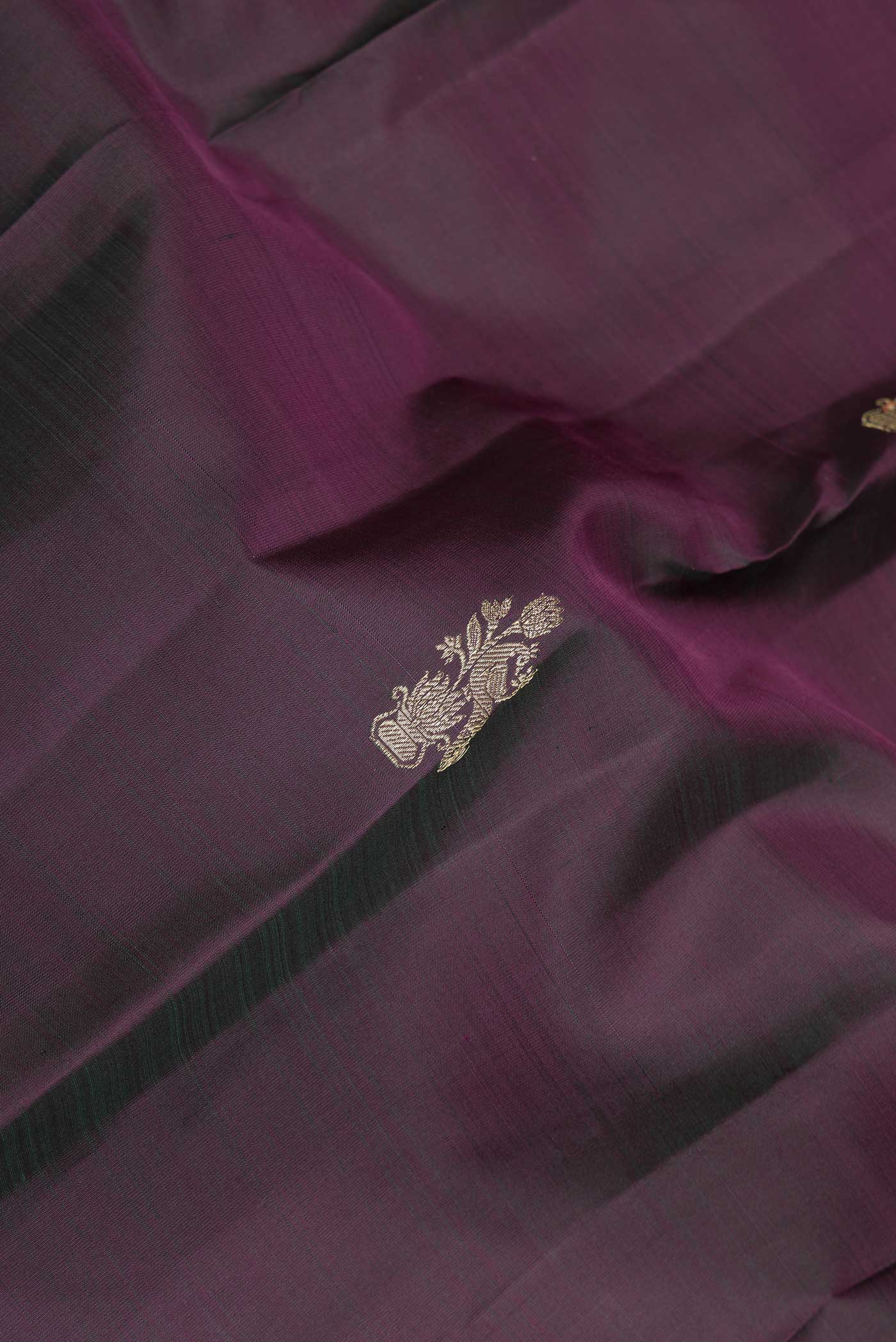 Close up of Mehandi Green Dual Tone Kanchipuram Saree with Zari Butta on the body and Zari Border displaying folds