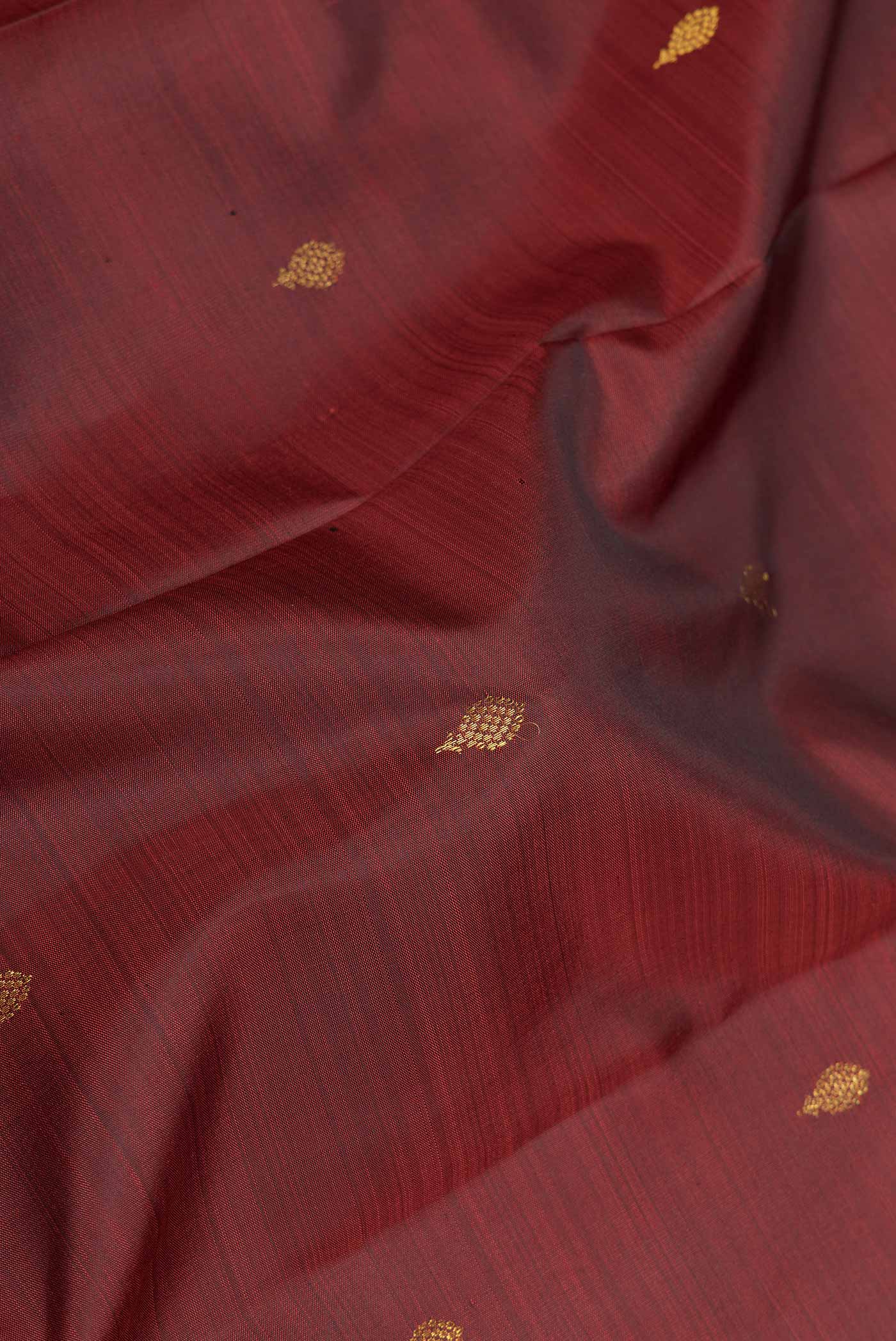 Close up of Maroon Dual Tone Kanchipuram Saree with Zari Butta on the body and Zari Border displaying folds