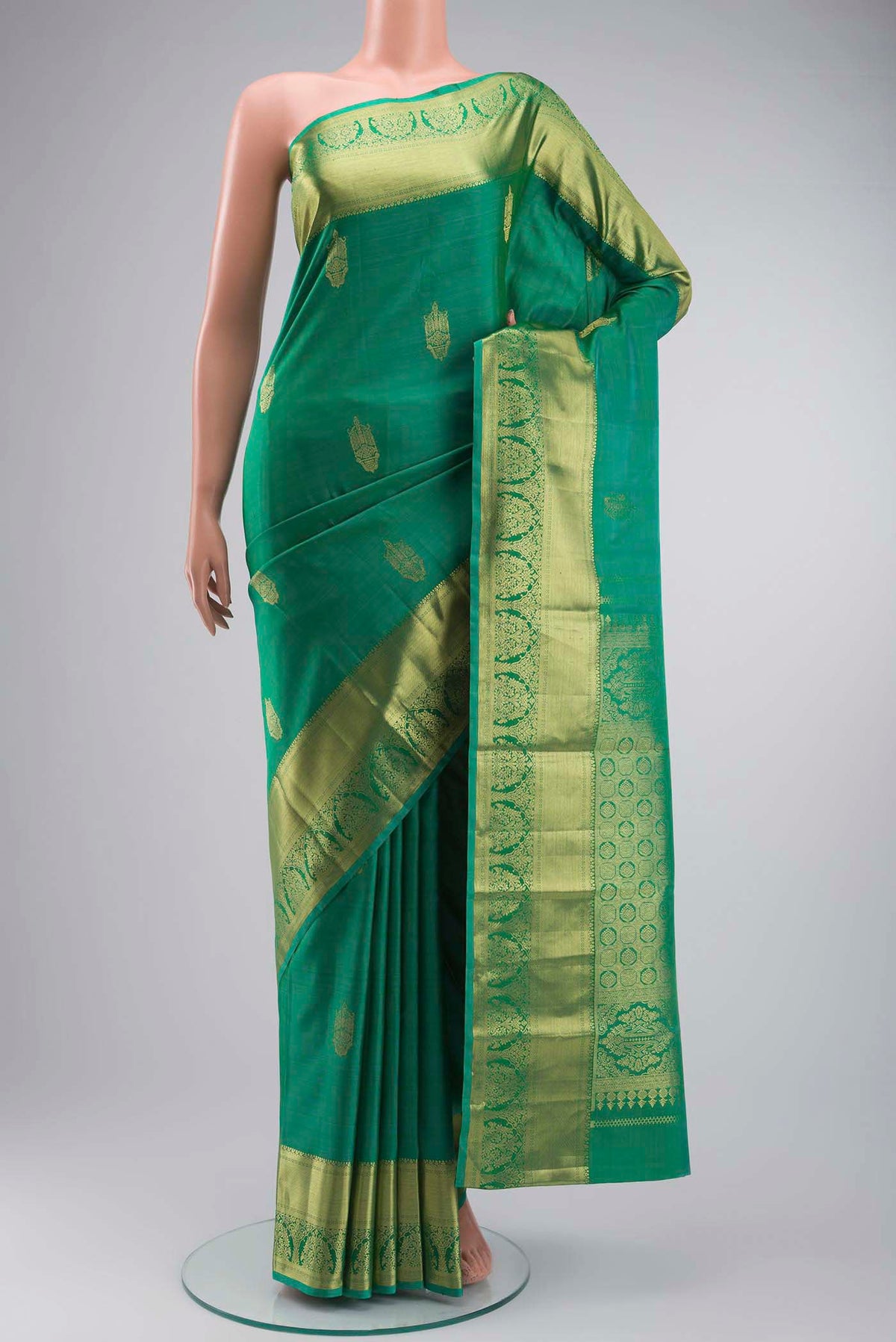 Green Kanchipuram Silk Saree with Zari Butta on the body and Zari Border displayed on a mannequin