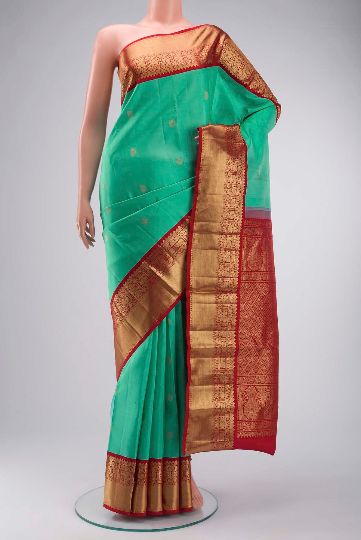 Green Kanchipuram Silk Saree with Zari Butta on the body and Zari Border displayed on a mannequin