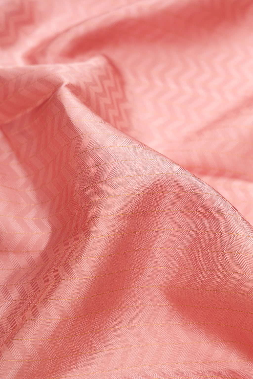 Close up of Rose Gold Kanjivaram Silk Saree with Jacquard design on the body and Temple Border.  displaying folds