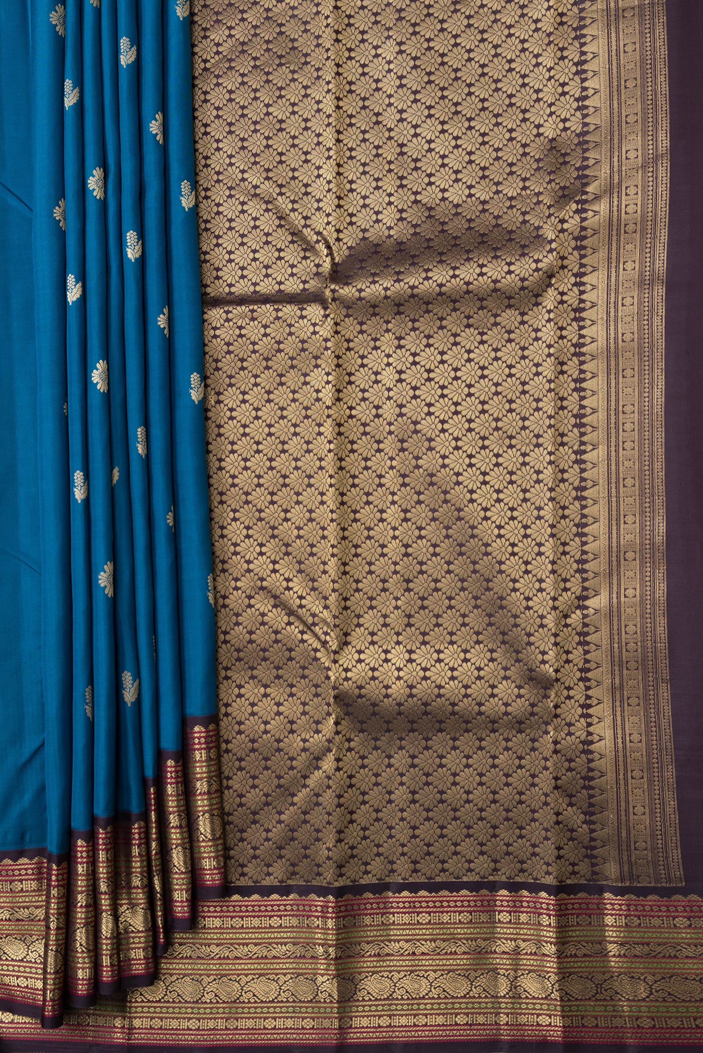 Pleats and pallu of Peacock Blue Dual Tone Kanchipuram Silk Saree with Zari Butta on the body and Zari Border. 