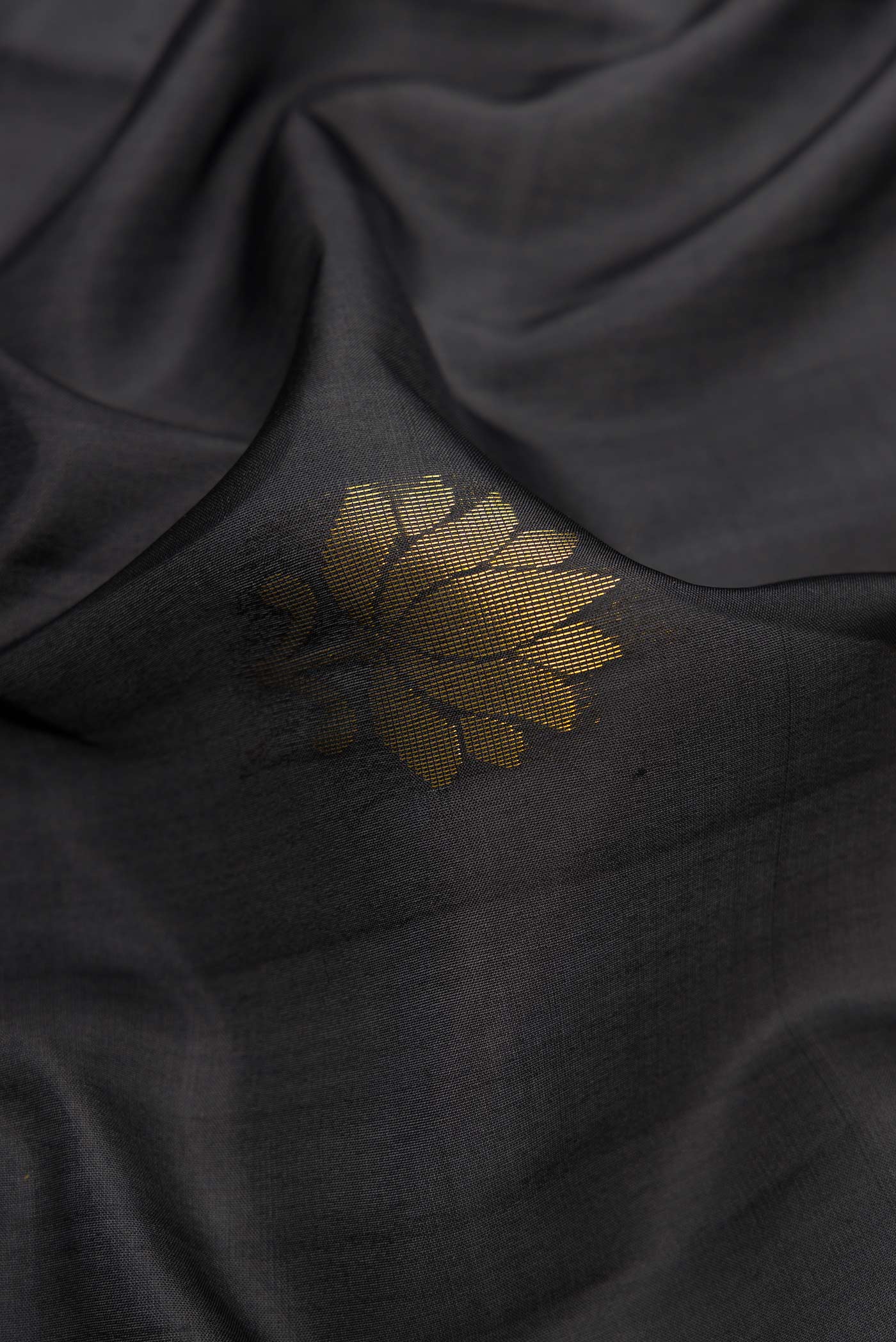 Close up of Black Dual Tone Soft Silk Saree with Zari Butta on the body and Fancy Border.  displaying folds