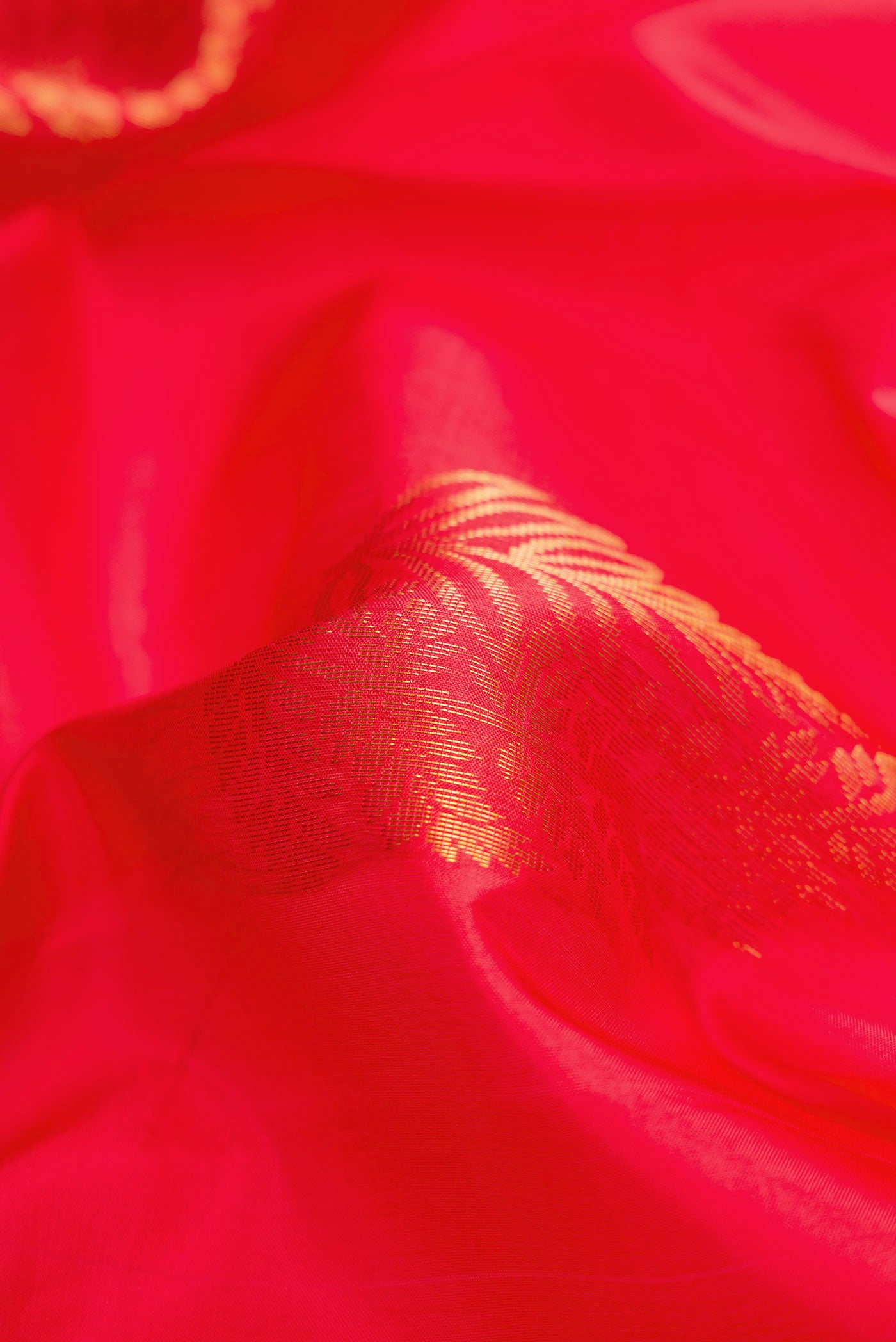 Close up of Red Dual Tone Soft Silk Saree with Zari Butta on the body and Zari Border.  displaying folds