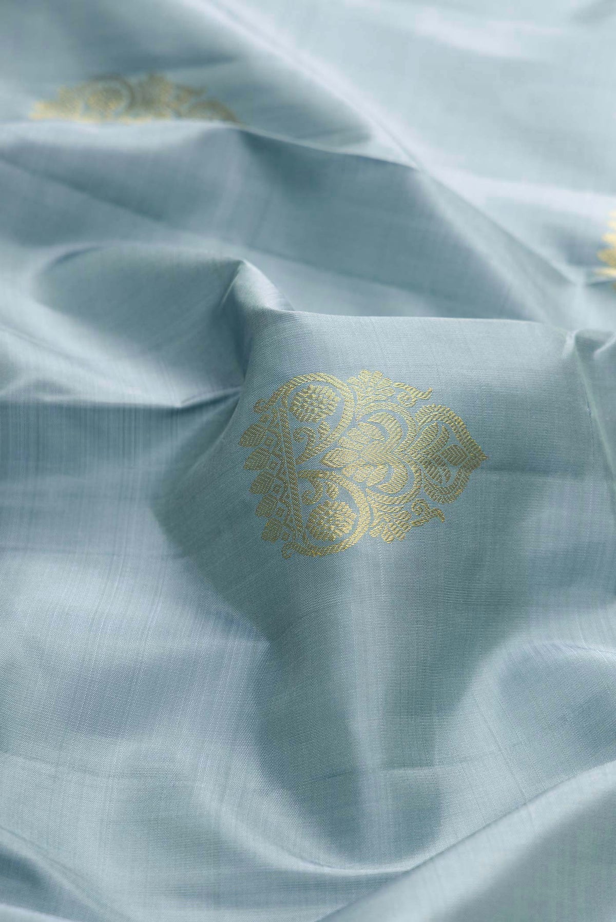 Close up of Grey Dual Tone Kanchipuram Silk Saree with Zari Butta on the body and Zari Border displaying folds