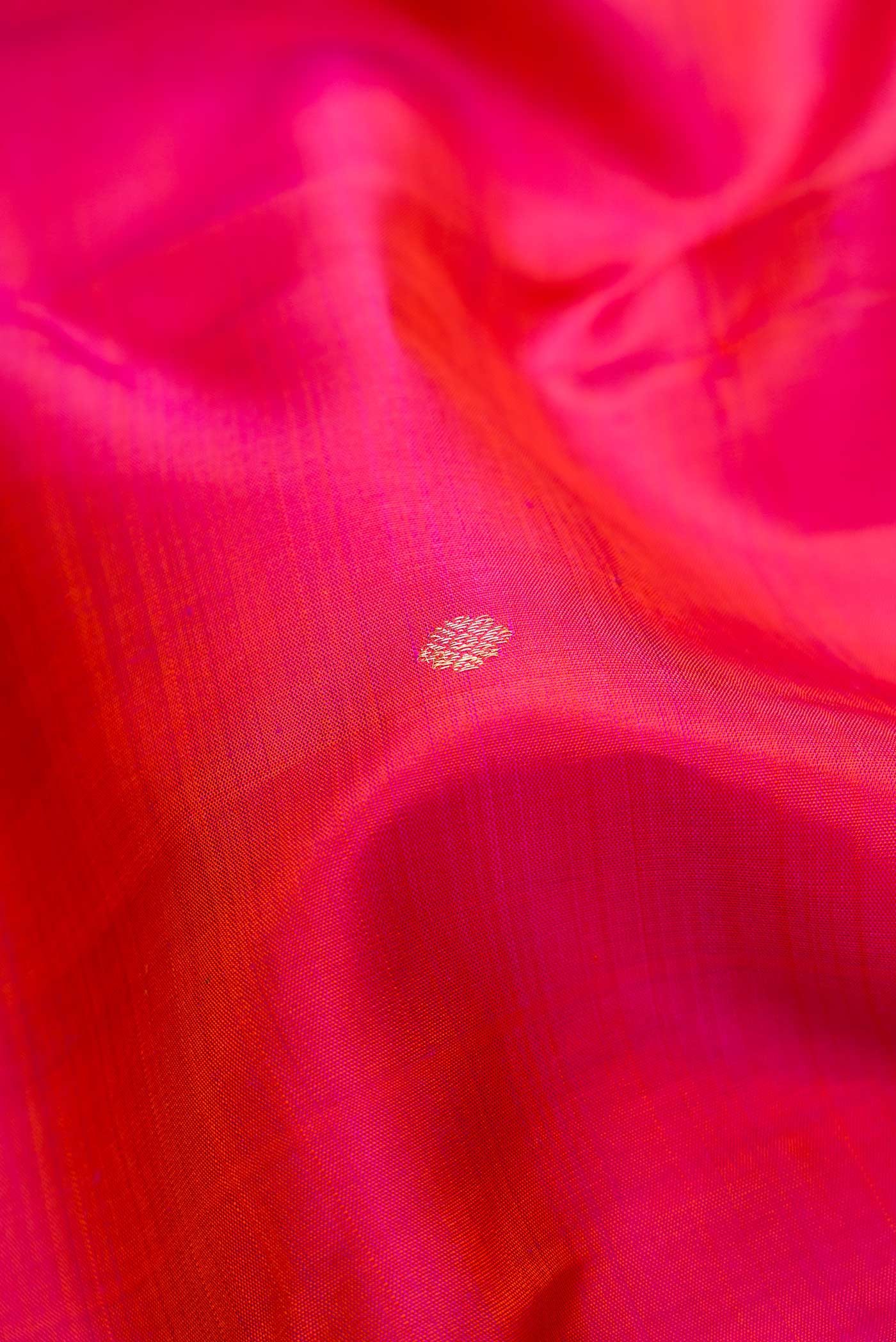 Close up of Coral Dual Tone Kanjivaram Silk Saree with Zari Butta on the body and Zari Border.  displaying folds