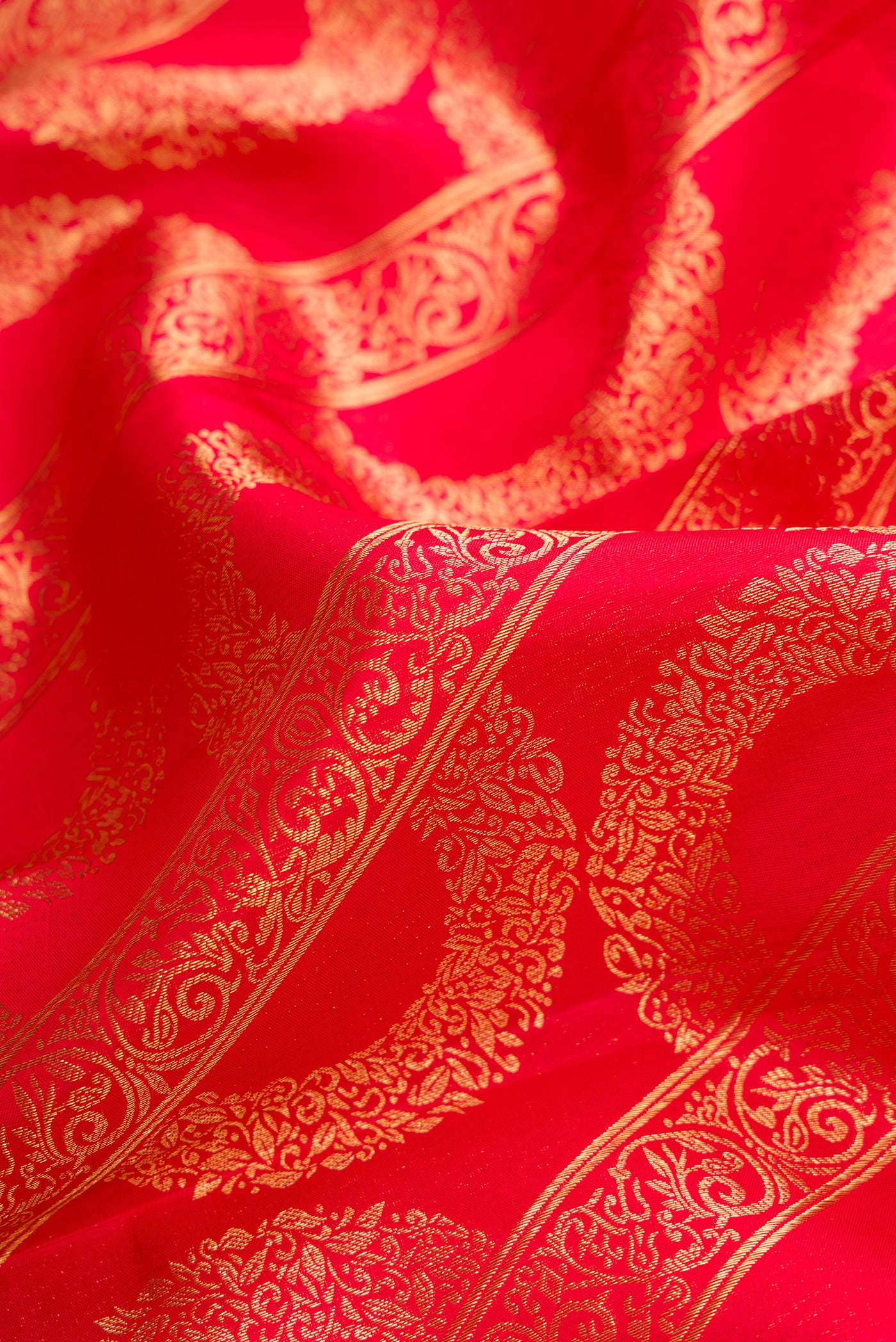 Close up of Red Dual Tone Kanchipuram Silk Saree with Zari Brocade on the body and Zari Border.  displaying folds