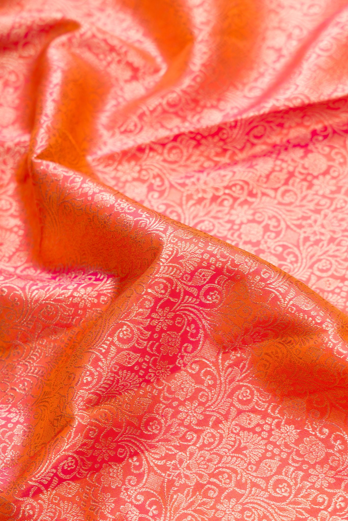 Close up of Brick Orange Dual Tone Kanchipuram Silk Saree with Zari Brocade on the body and Fancy Border.  displaying folds
