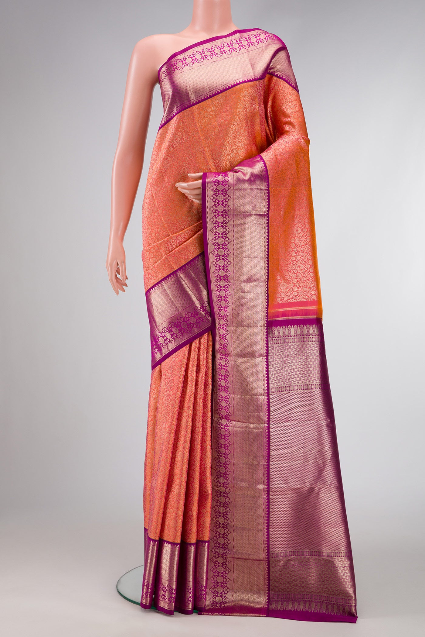 Brick Orange Dual Tone Kanchipuram Silk Saree with Zari Brocade on the body and Fancy Border.  displayed on a mannequin