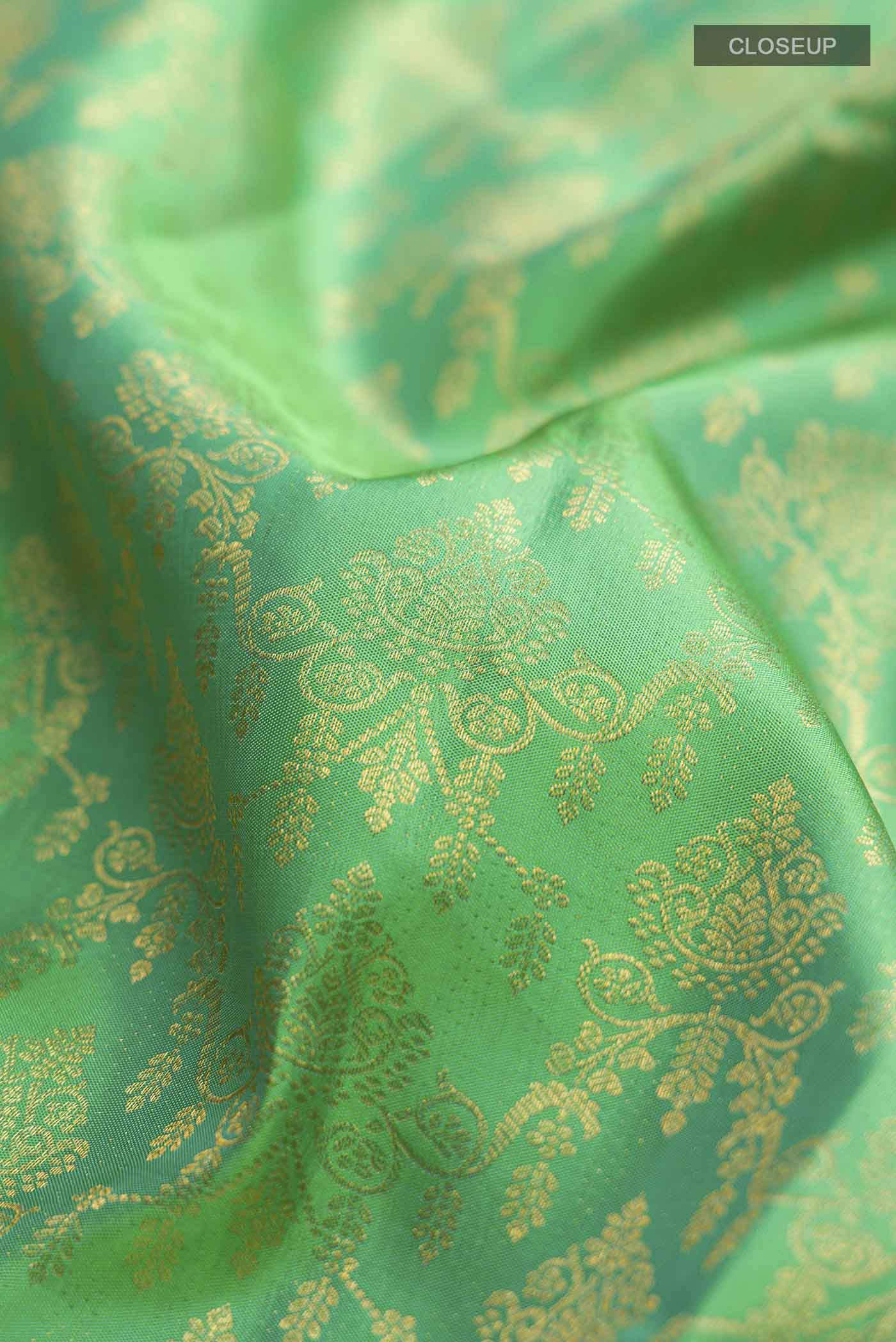 Close up of Green Kanchipuram Silk Saree with Zari Brocade on the body and Zari Border displaying folds