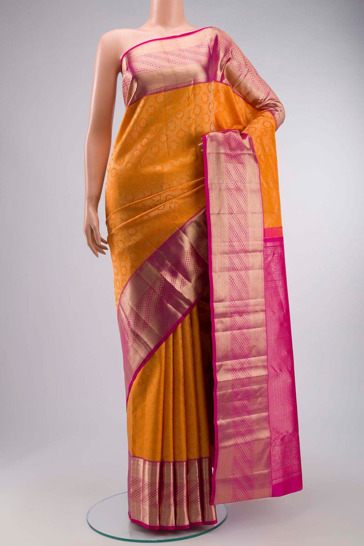 Orange Kanchipuram Silk Saree with Zari Brocade on the body and Zari Border displayed on a mannequin