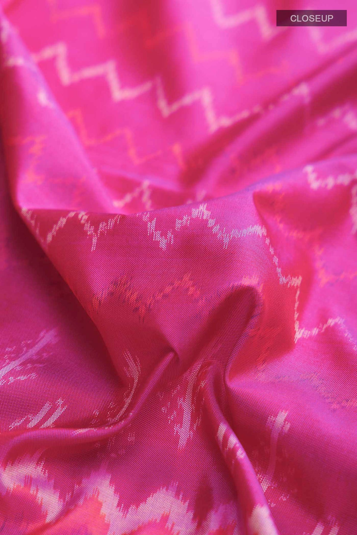 Close up of Pink Pochampally Silk Saree with Pure Ikat on the body and Zari Border displaying folds