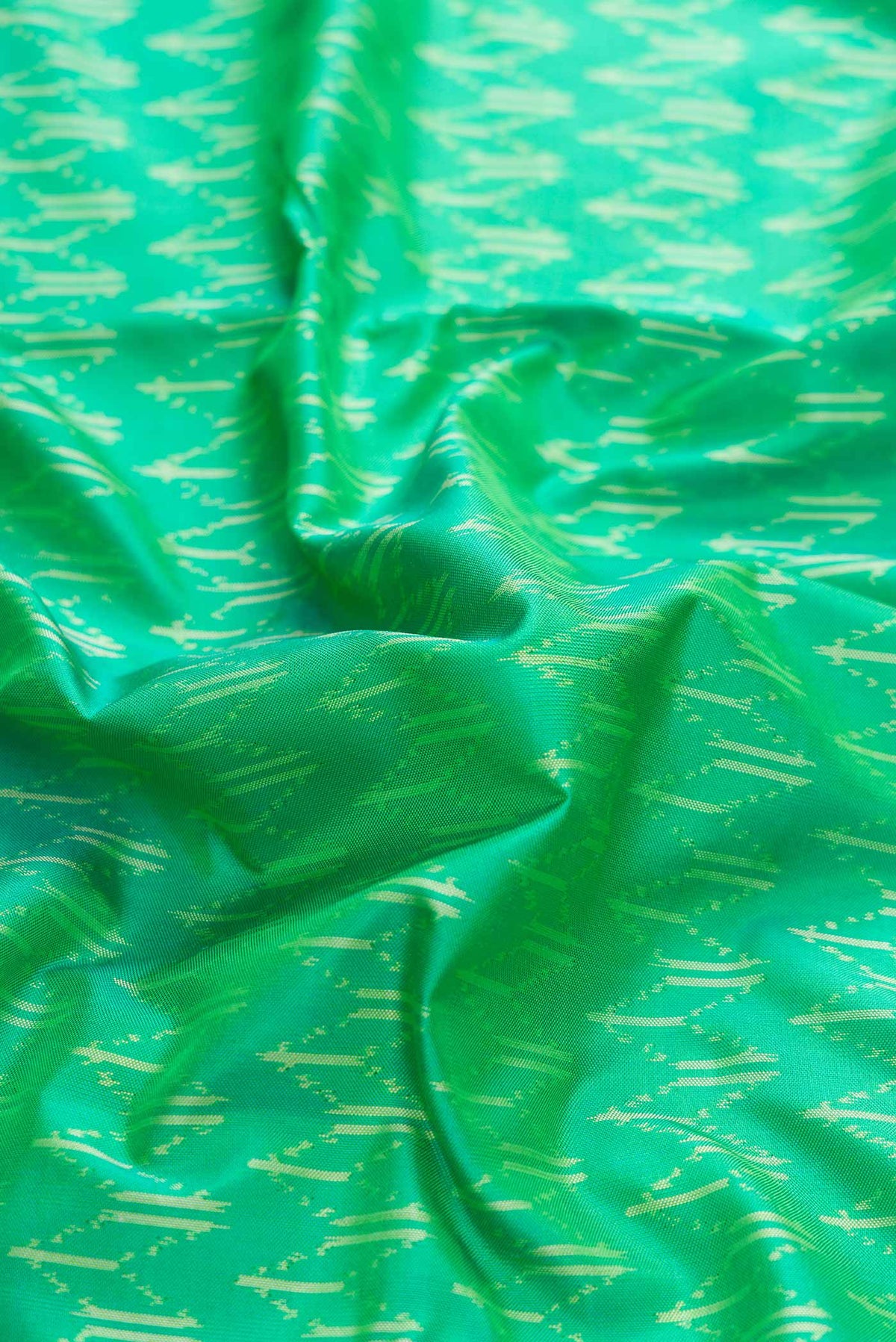 Close up of Green Dual Tone Double Ikat Saree with Ikat Print on the body and Zari Border displaying folds