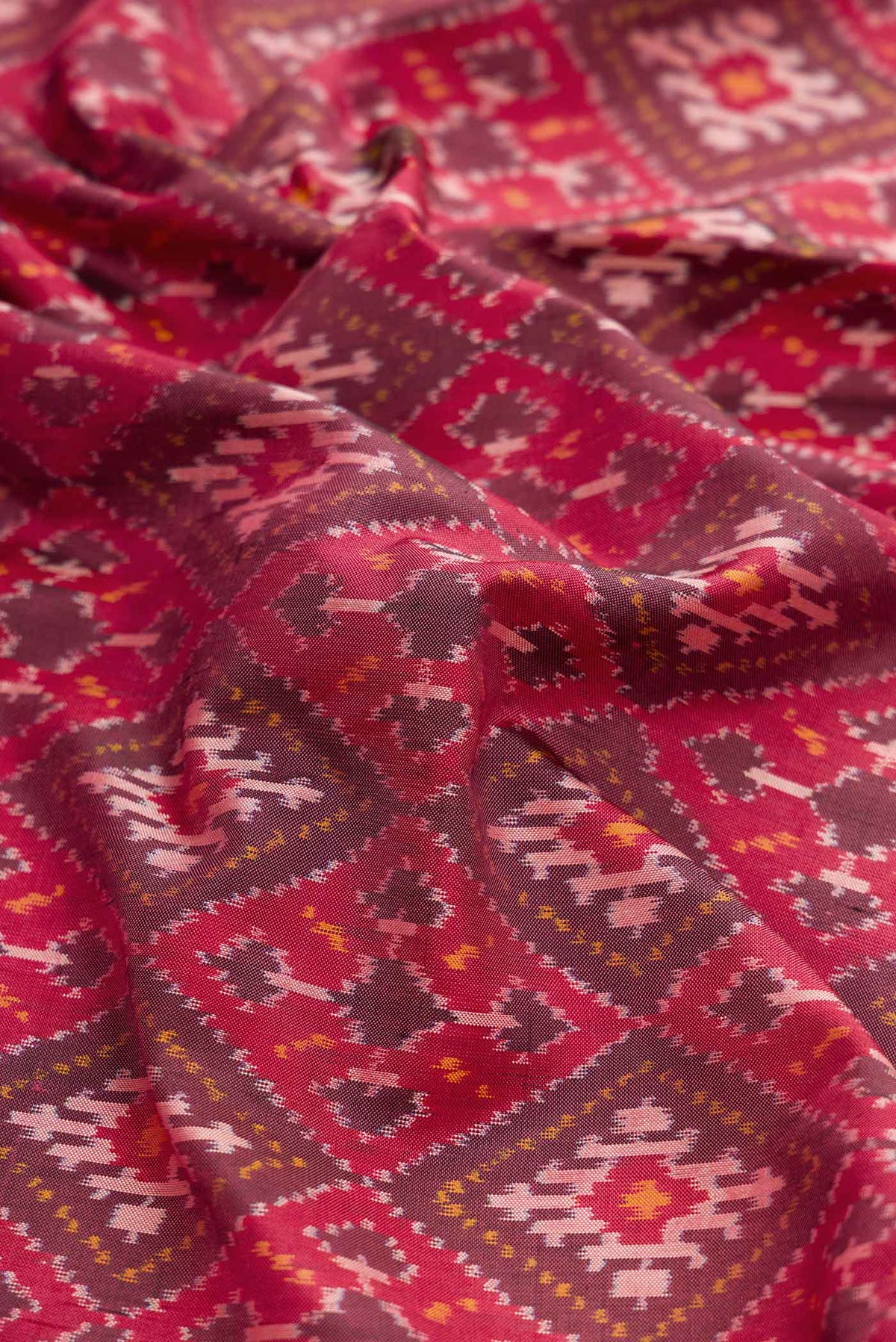 Close up of Dark Mauve Dual Tone Double Ikat Saree with Ikat Print on the body and Zari Border displaying folds
