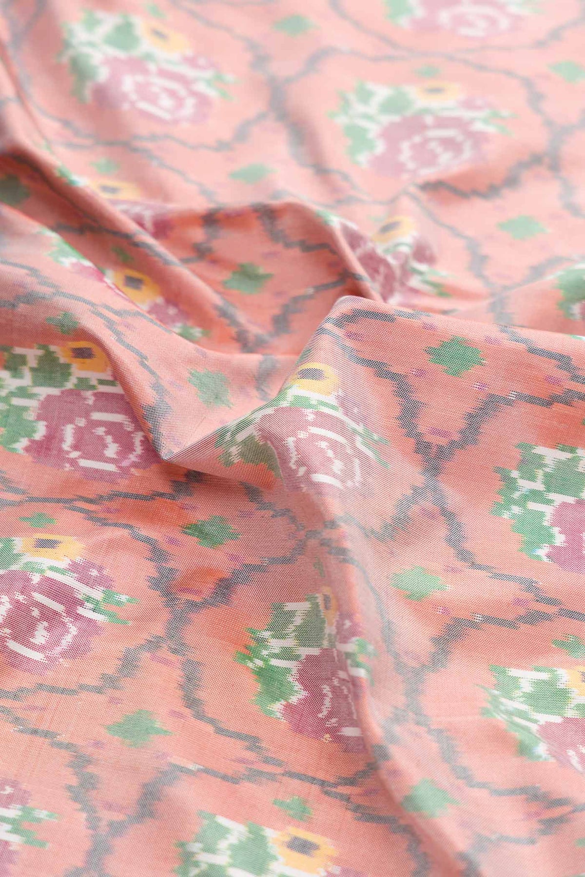 Close up of Golden Peach Dual Tone Double Ikat Saree with Ikat Print on the body and Plain Border displaying folds