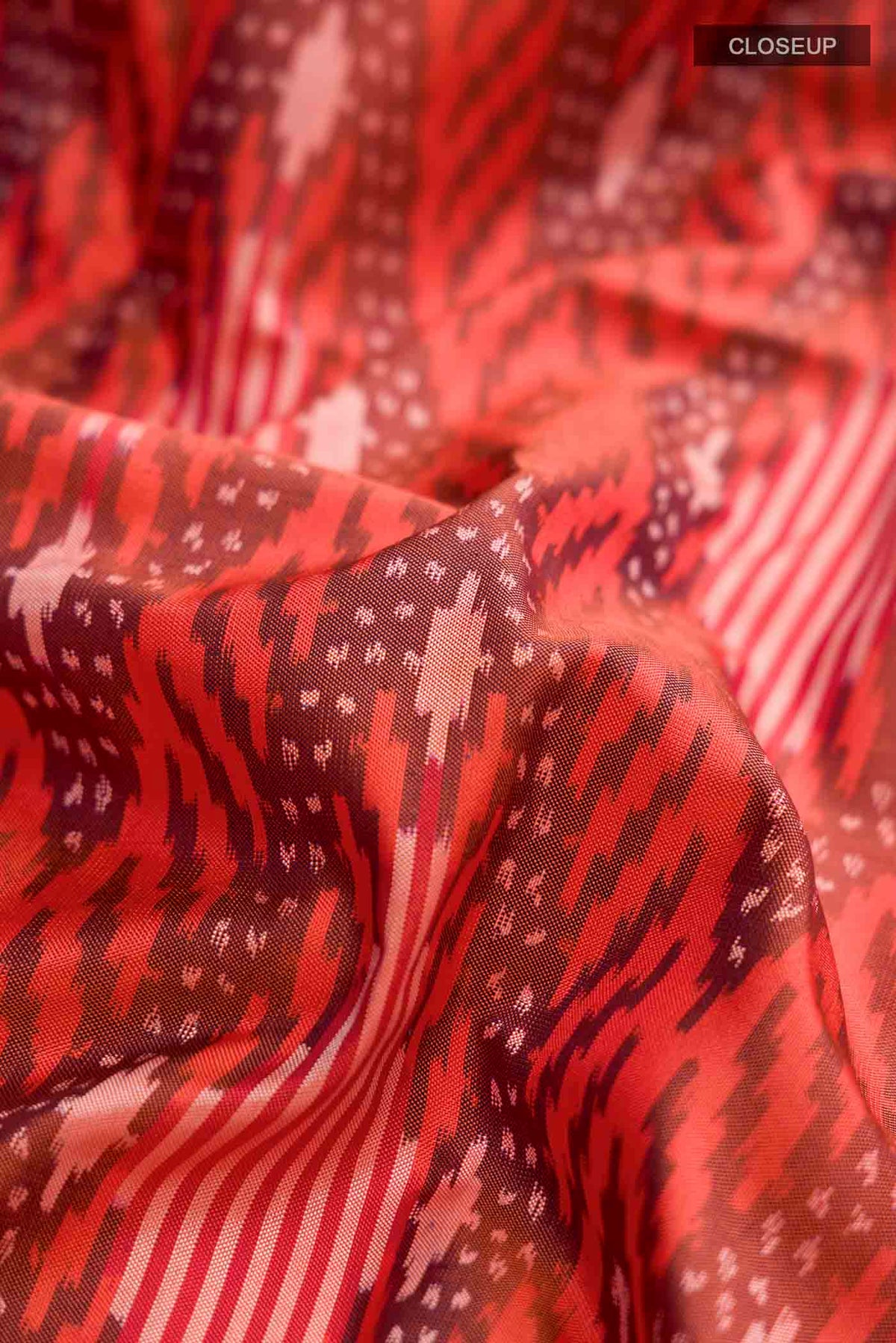 Close up of Orange Pochampally Silk Saree with Pure Ikat on the body and Plain Border displaying folds