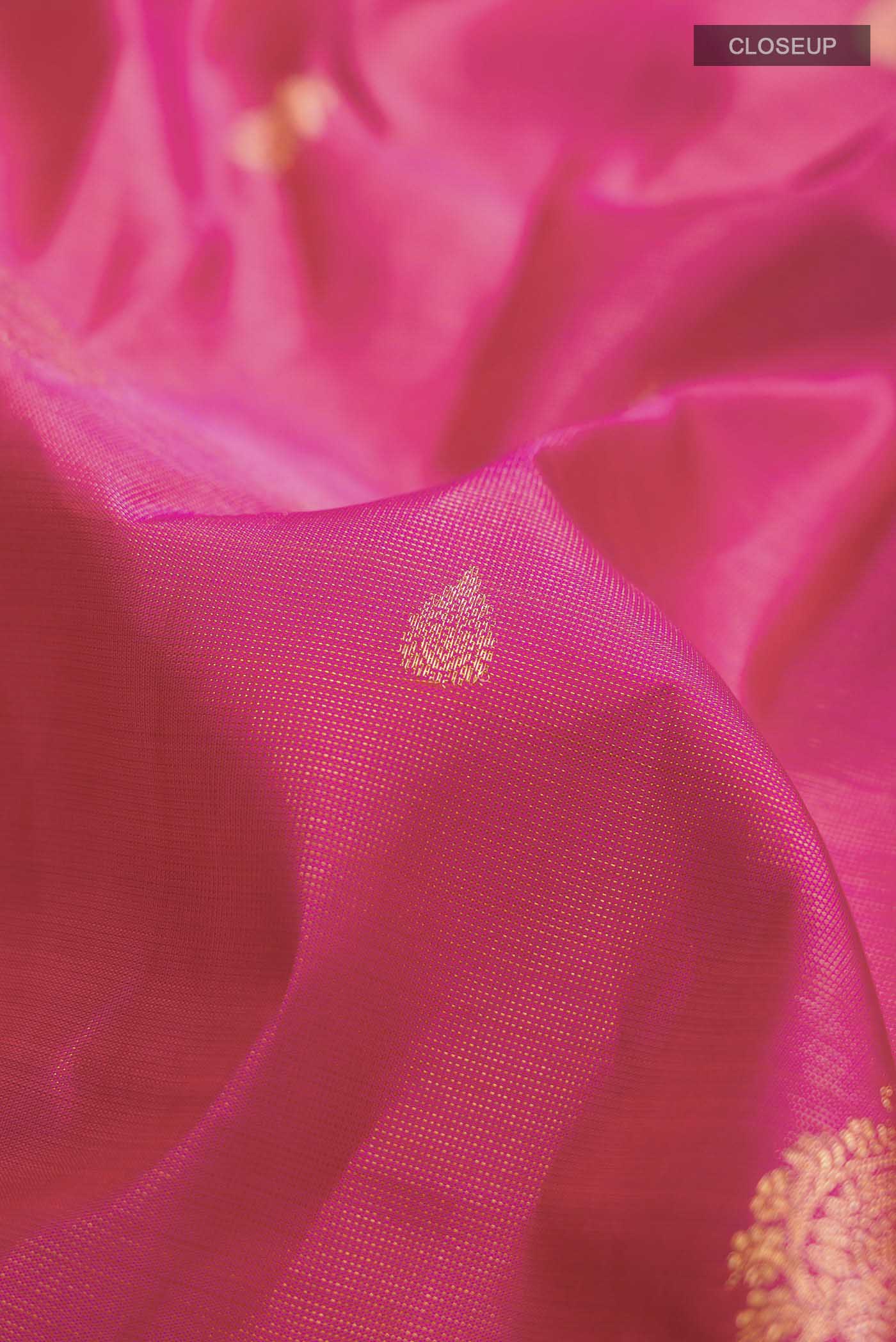 Close up of Pink Kanchipuram Silk Saree with Zari Butta on the body and Zari Border displaying folds