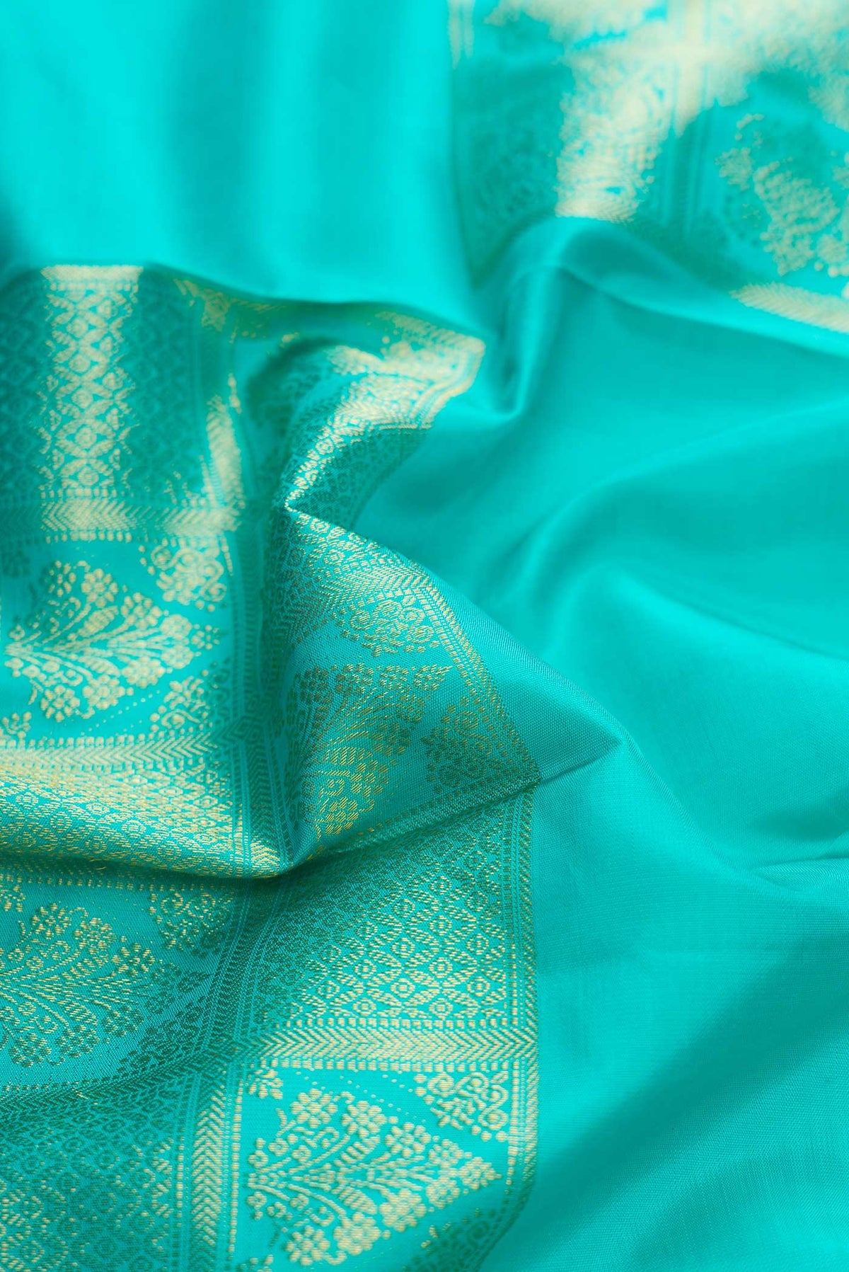 Close up of Sky Blue Dual Tone Kanchipuram Silk Saree with Zari Butta on the body and Without Border displaying folds