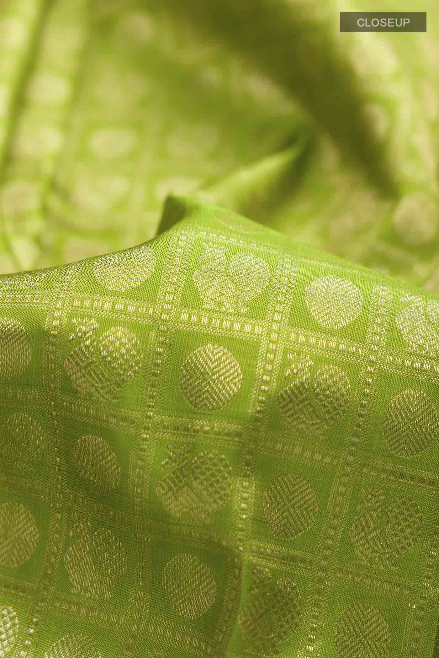 Close up of Green Kanchipuram Silk Saree with Zari Brocade on the body and Zari Border displaying folds