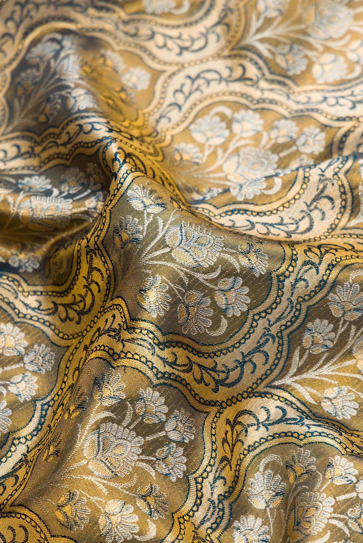 Close up of Mehandi Green Dual Tone Kanchipuram Tissue Silk Saree with Zari Brocade on the body and Zari Border.  displaying folds