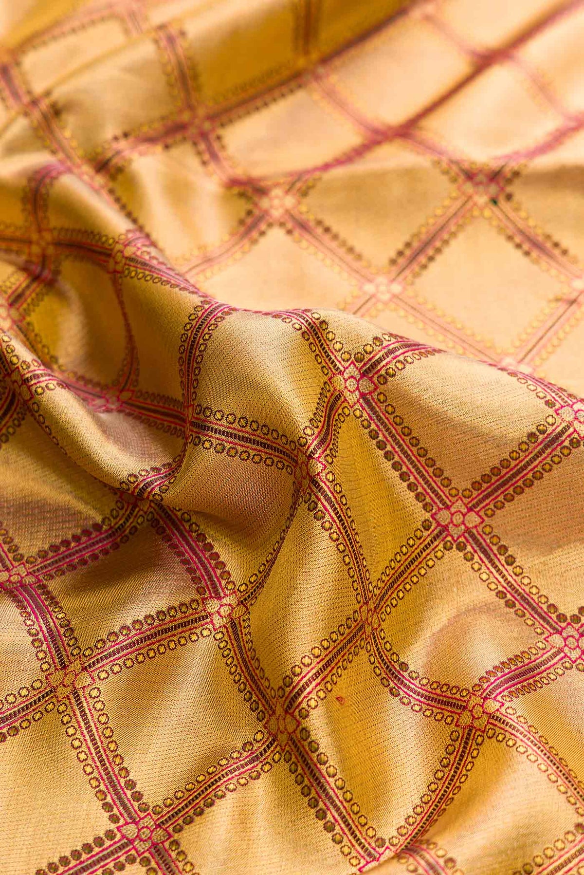Close up of Gold Dual Tone Kanchipuram Tissue Silk Saree with Zari Brocade on the body and Zari Border displaying folds